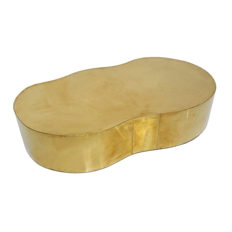 Curved coffee table with wooden structure covered in brass.