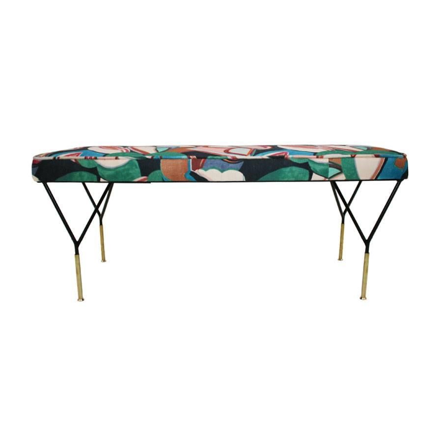 Italian bench with structure realized in iron lacquered in black and legs finished in covers of brass and upholstered in cloth of 