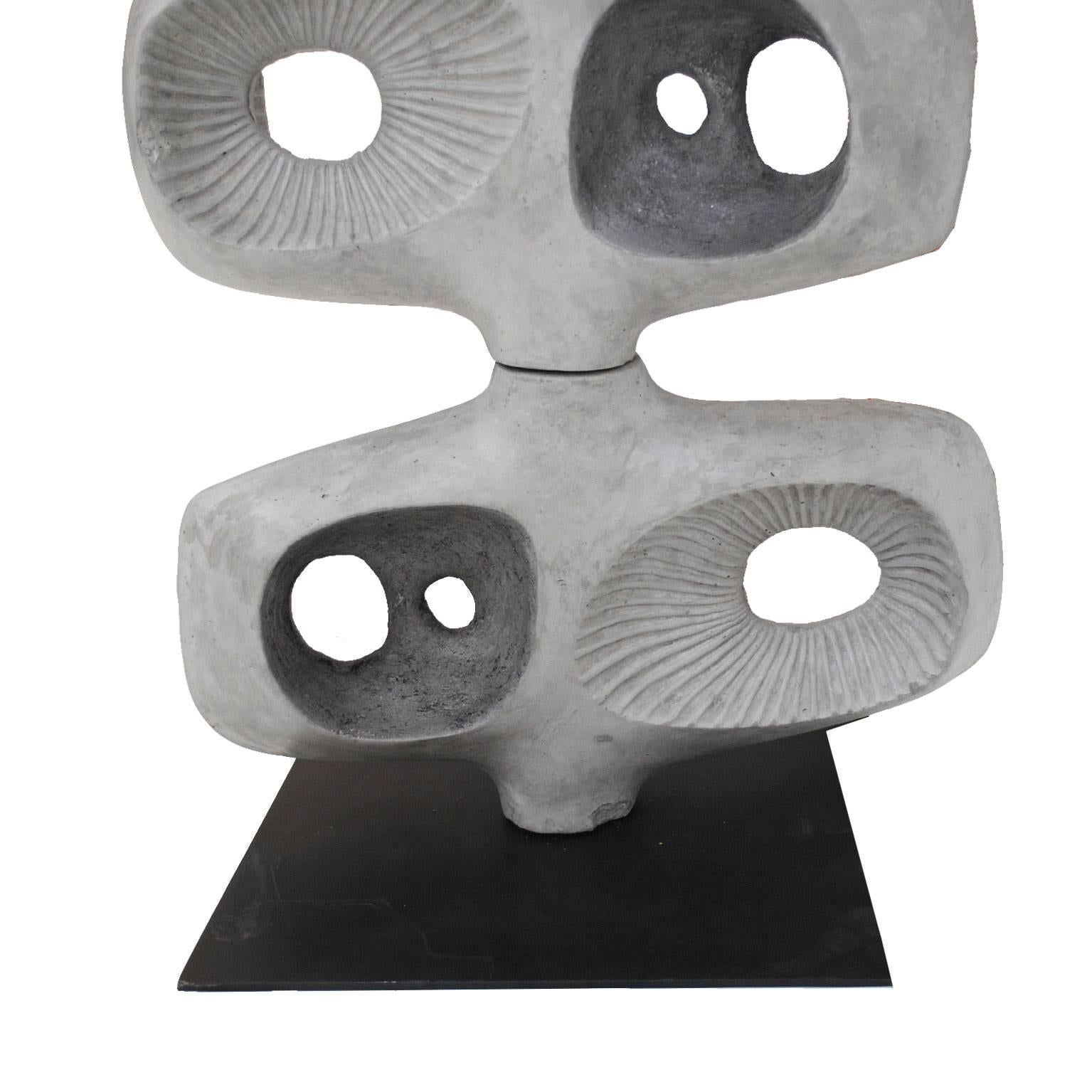 Sculptural totem composed by eight concrete pieces over a central metal bolt, inspired on the Barbara's Hepworth works. 