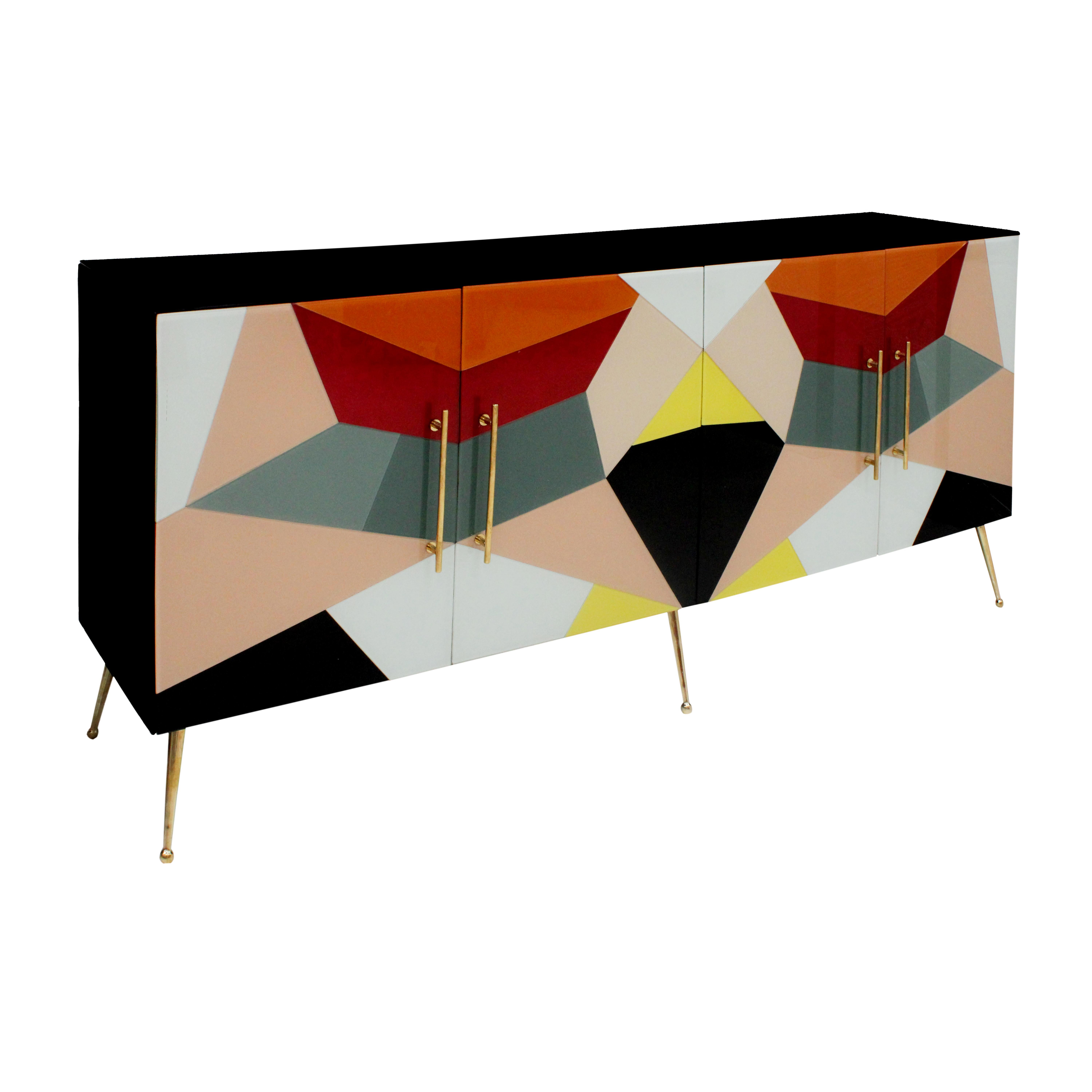 Credenza italiana di metà secolo, con struttura in legno massiccio, rivestita in vetro colorato con un disegno geometrico. Presenta quattro ante con maniglie in ottone lucido e gambe coniche in ottone. Pezzo originale, completamente restaurato con