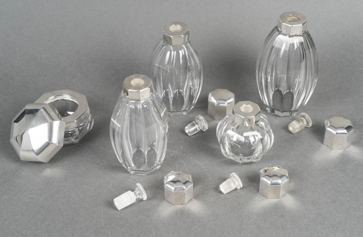 Set di quattro bottiglie più un unguentario in cristallo Baccarat, con bordi smussati, nello stile del modello Harcourt.

Le bottiglie sono chiuse con tappi di cristallo Emery, numerati, con

Timbro inciso Baccarat 1936 / Label di carta 