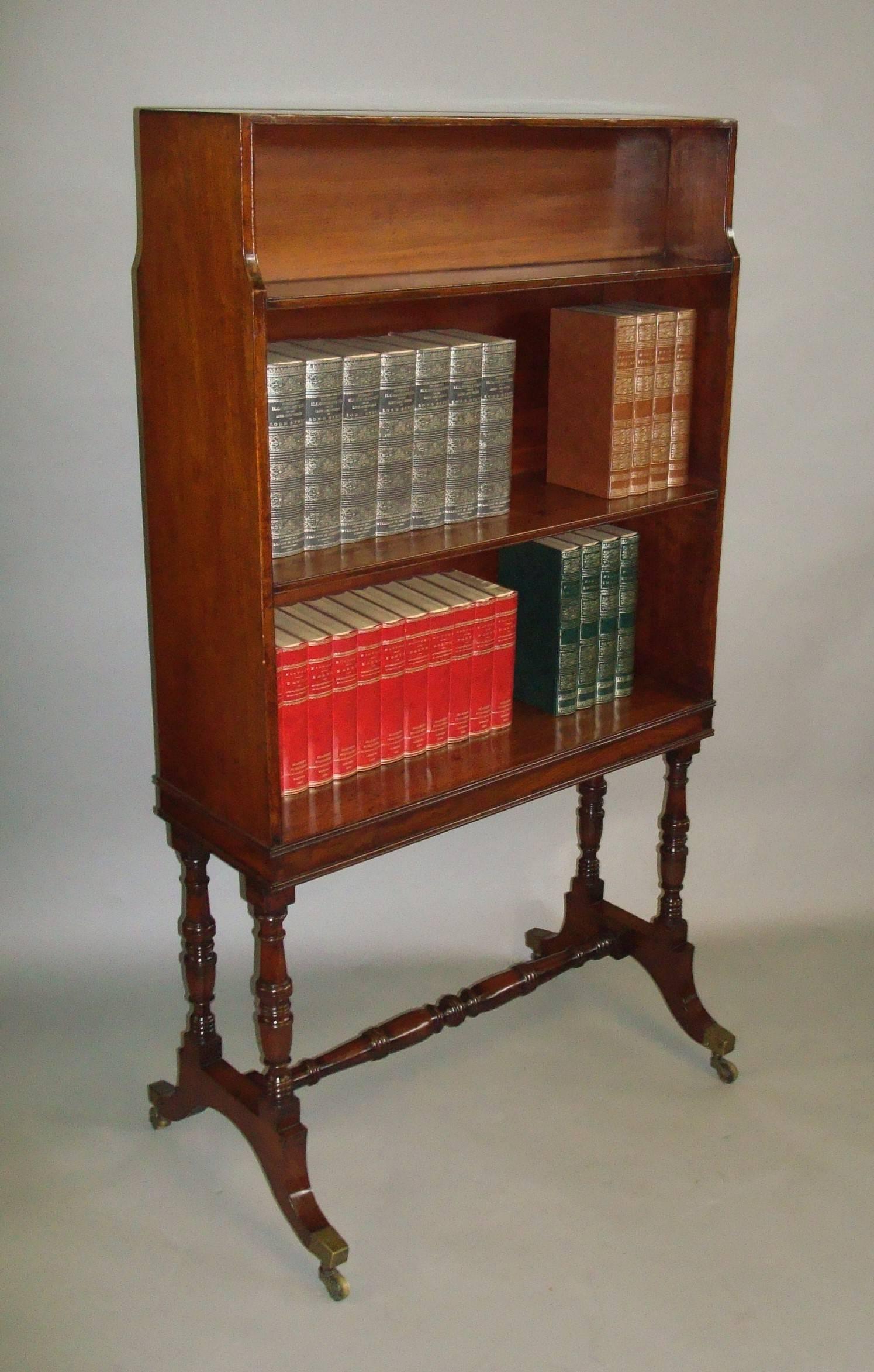 Good Regency mahogany waterfall open bookcase of freestanding form; the front of the bookcase with fixed tiered shelves and reeded edges, the reverse with a small open shelf and paneled back below. Raised on a figured mahogany shallow frieze with