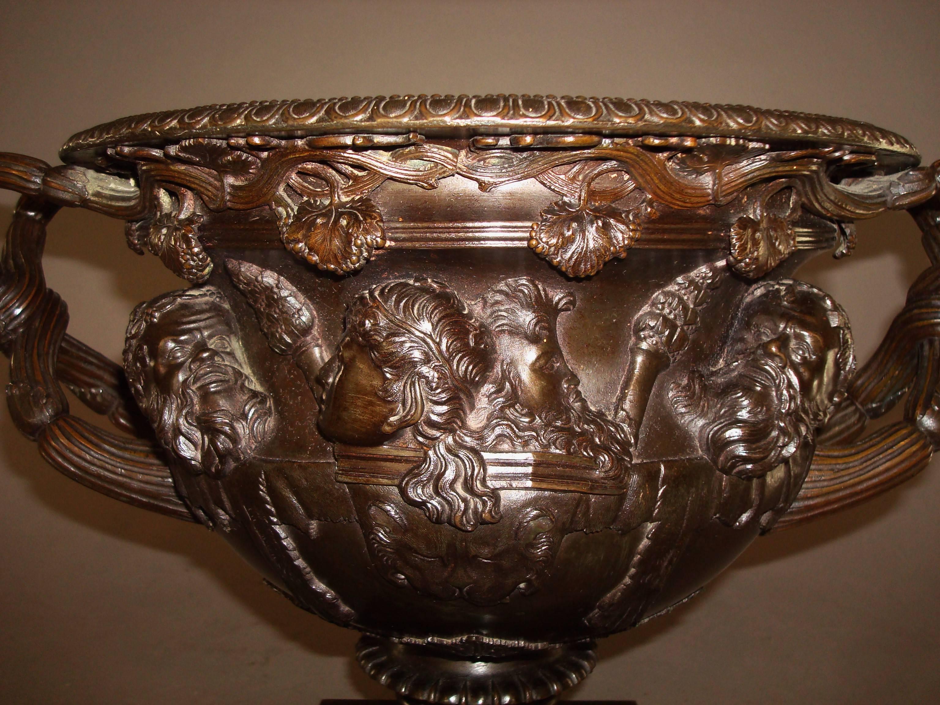 Good 19th century Grand Tour bronze warwick vase, of large proportions; the rim with an egg and dart border above trailing vine leaves and the classical masks below cast in high relief; the handles to either side being entwined vine branches, with