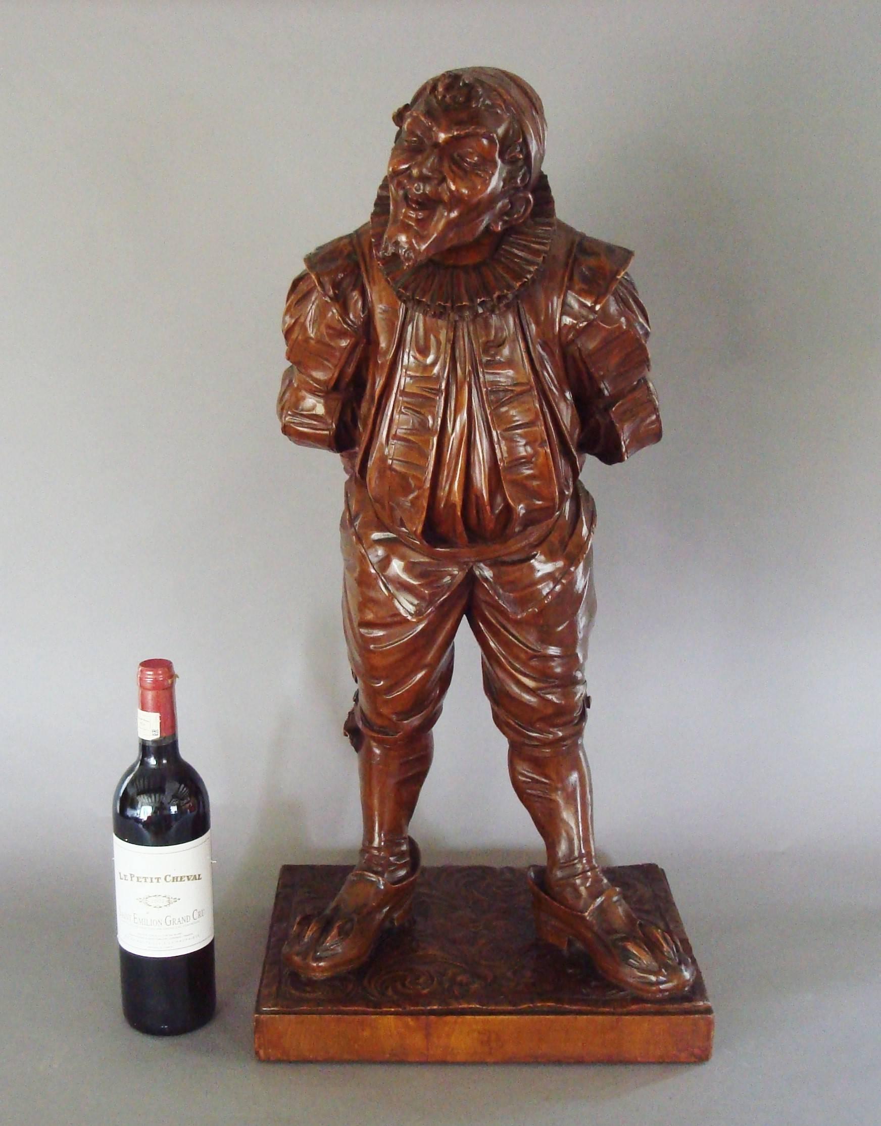 Good 19th century Italian carved walnut 'Gobbo' sculpture
of great charm; from the renowned 'Eric Bramall Collection'; the standing figure leaning forward with his hunchback, and hands clasped behind his back, dressed in traditional costume with