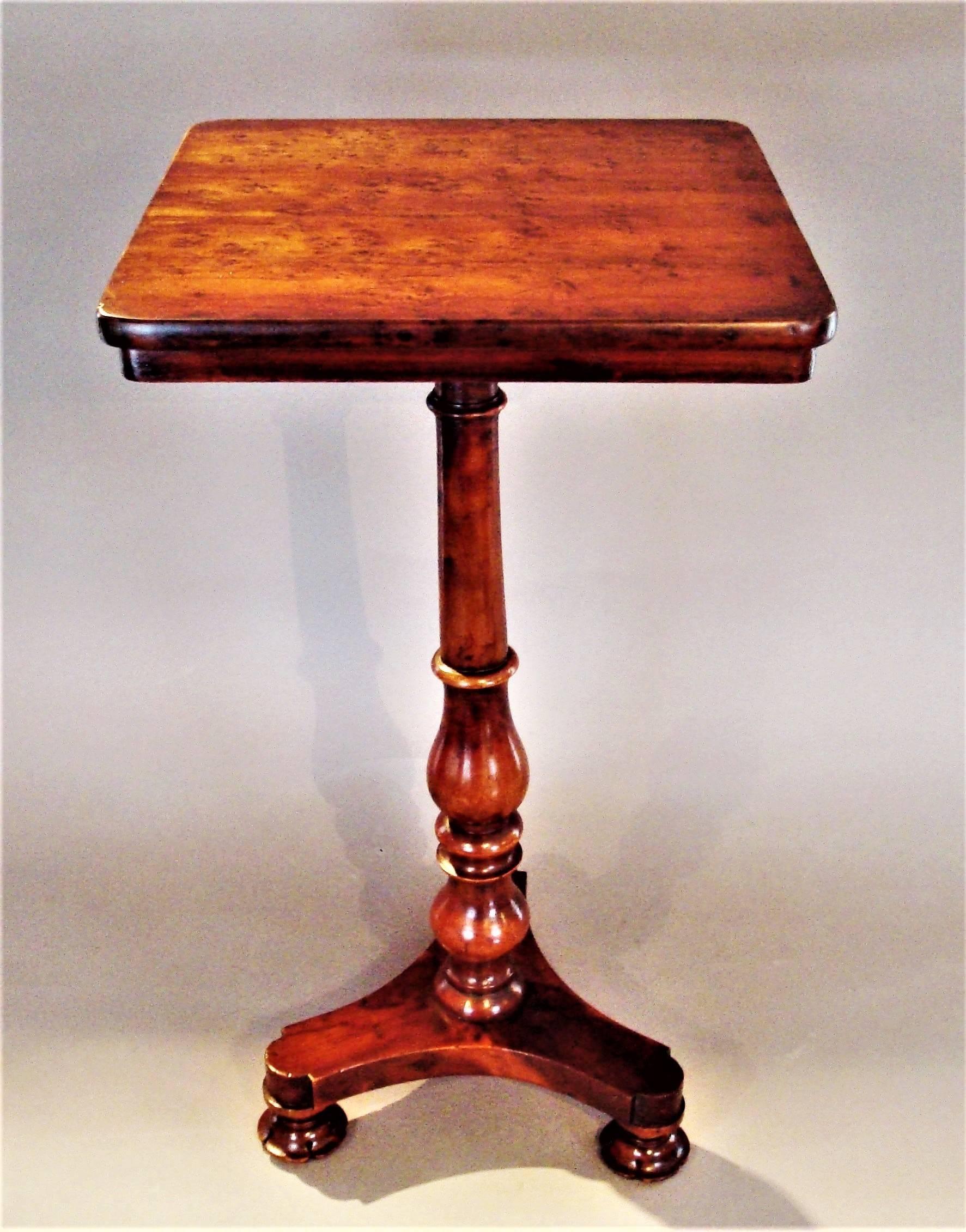 Unusual Regency yew wood wine or occasional table; with a tilting top and of small proportions; the burr yew square top with rounded corners and an inset shallow frieze below raised on a turned vase tapering column on a shapely tri-form base
