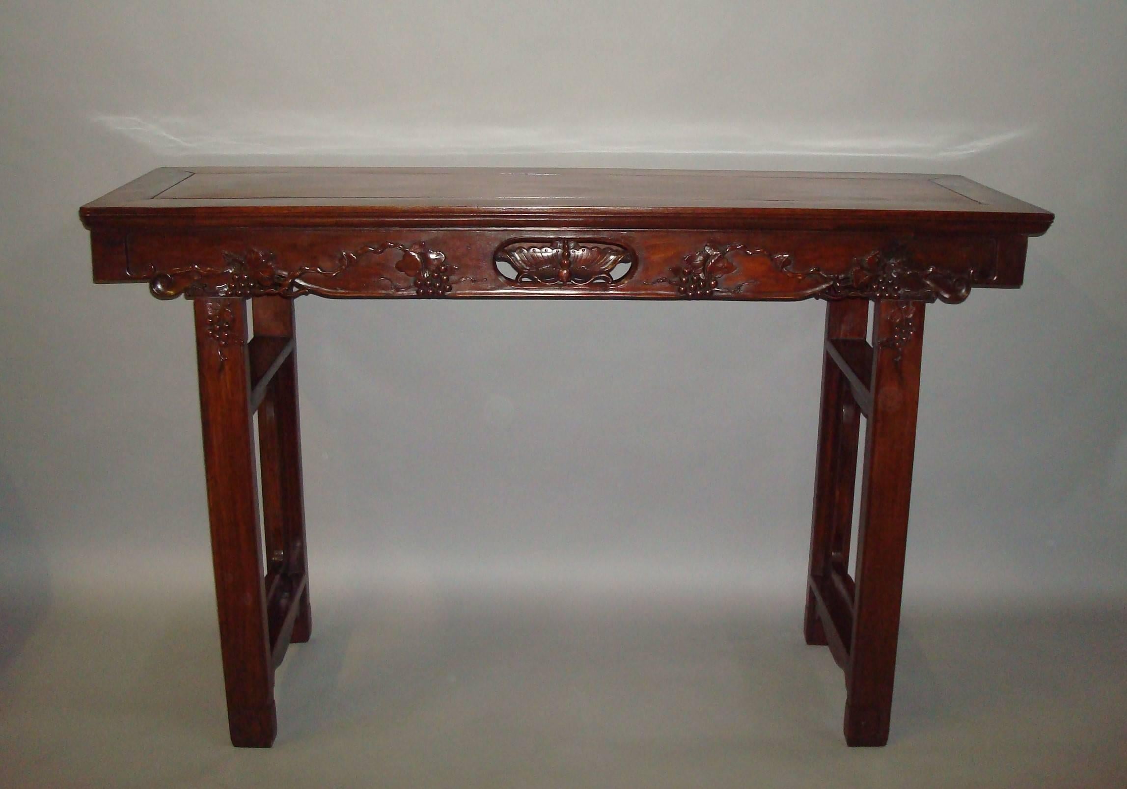Good 19th century pair of Chinese Hongmu alter tables, the figured rectangular tops of cleated form above carved frieze centred by a carved and pierced panel of a dragonfly, flanked with trailing grapevine and lotus flowers, raised on moulded legs