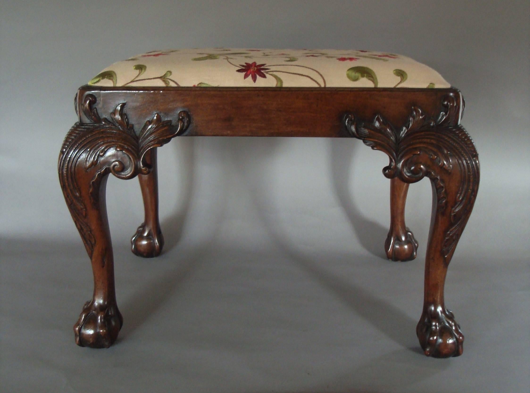 Good 19th century carved mahogany stool in George II manner, the drop in seat upholstered in linen with embroidered silk flowers housed in a moulded edge seat frame, raised on very bold cabriole legs finely carved with scrolling acanthus and foliate