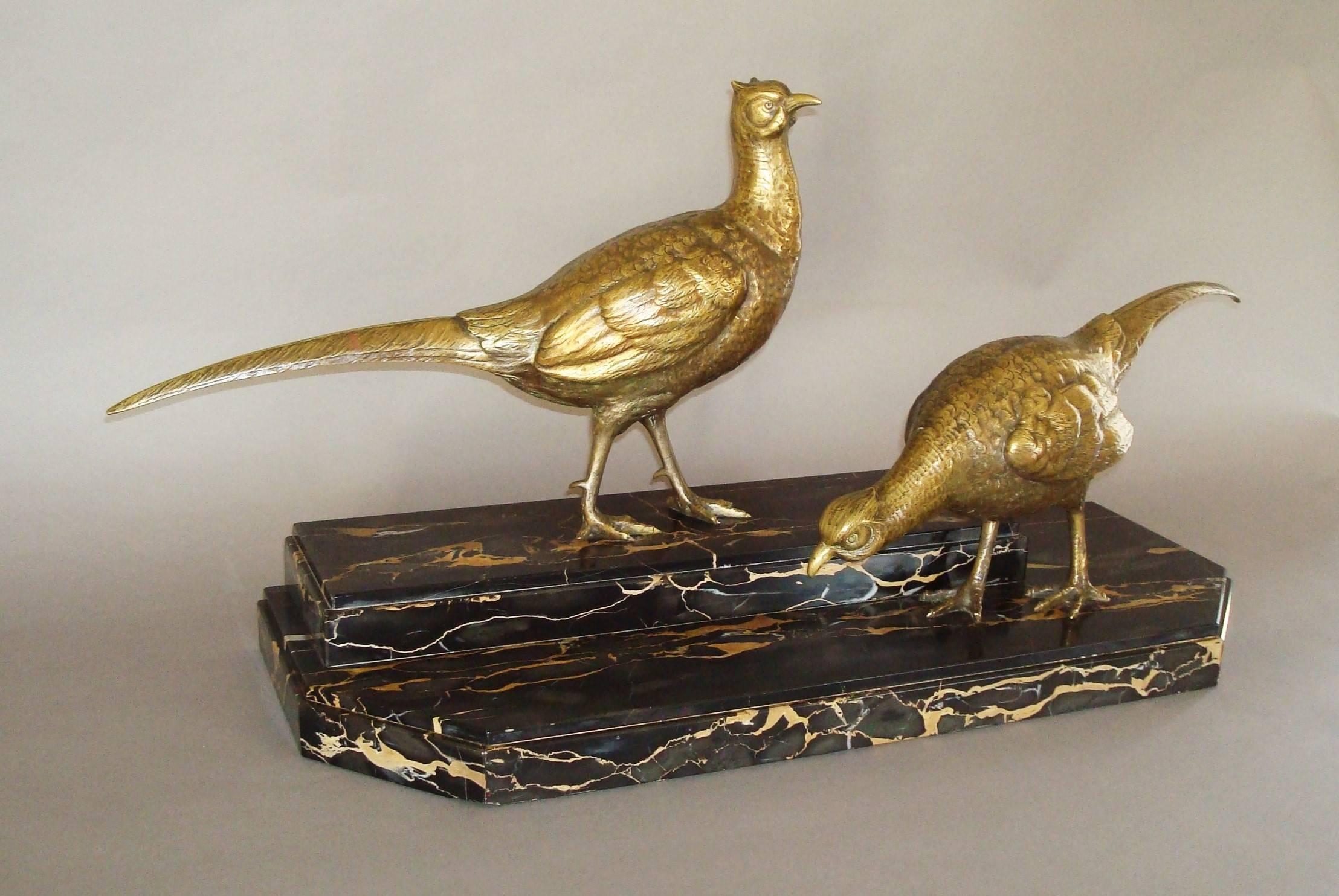 Early 20th century large pair of gilt bronze pheasants by Ignacio Gallo. The two gilt bronze cock pheasants, one alert, the other foraging, raised on a substantial Porto marble stepped base with canted front corners and a thin moulded edge. Signed
