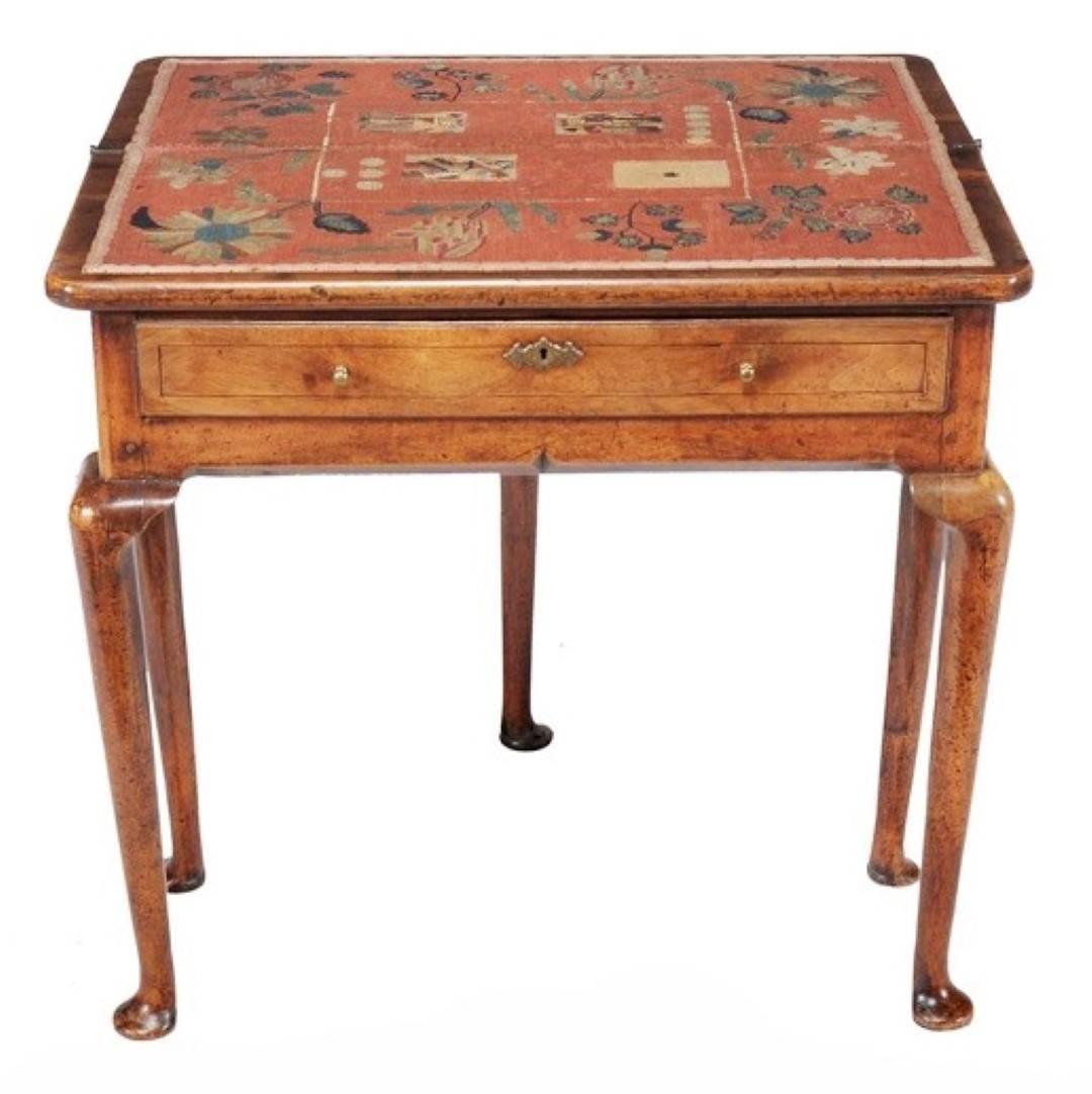 Good George I walnut card table having a rare needlework interior; of neat proportions; the quarter veneered top with stringing to the border opening to reveal the unusual needlework interior depicting playing cards within a border of flowers and