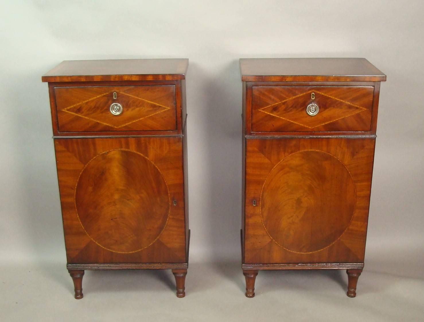 Good George III pair of mahogany side cabinets of small proportions, the rectangular crossbanded tops with an ebony strung edge above a well figured mahogany drawer with a narrow, satinwood banded, diamond panel and a circular brass handle; above a