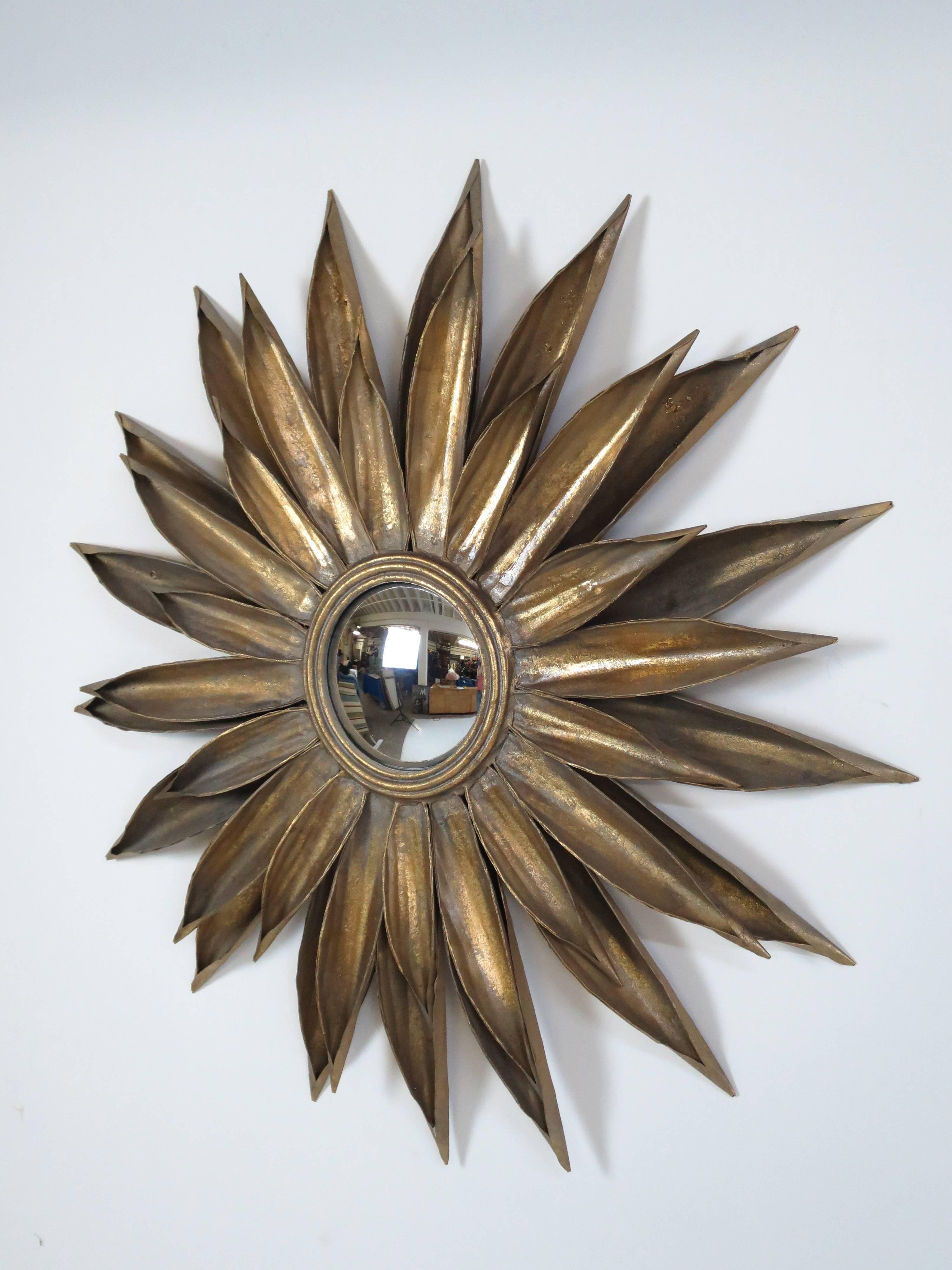 Dynamic wall-mounted French sunburst mirror. Well executed example of a Classic design. Gold gilt over metal with convex mirror.