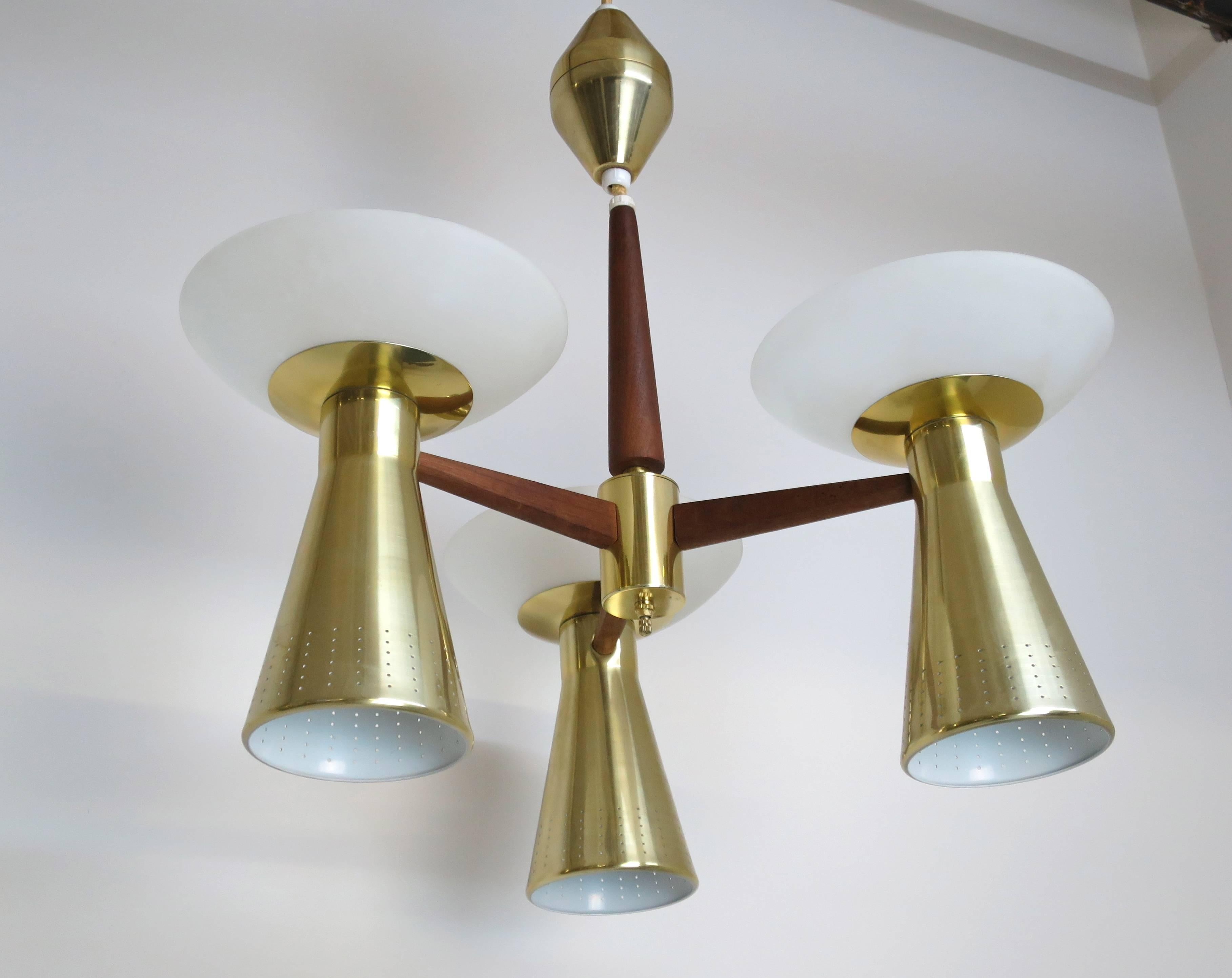 Modernist perforated brass and walnut chandelier features three double sconces. Sockets on both the bottom and top (Six bulbs total with three-way switch). Fixture has been professionally rewired.
Fixture is 22