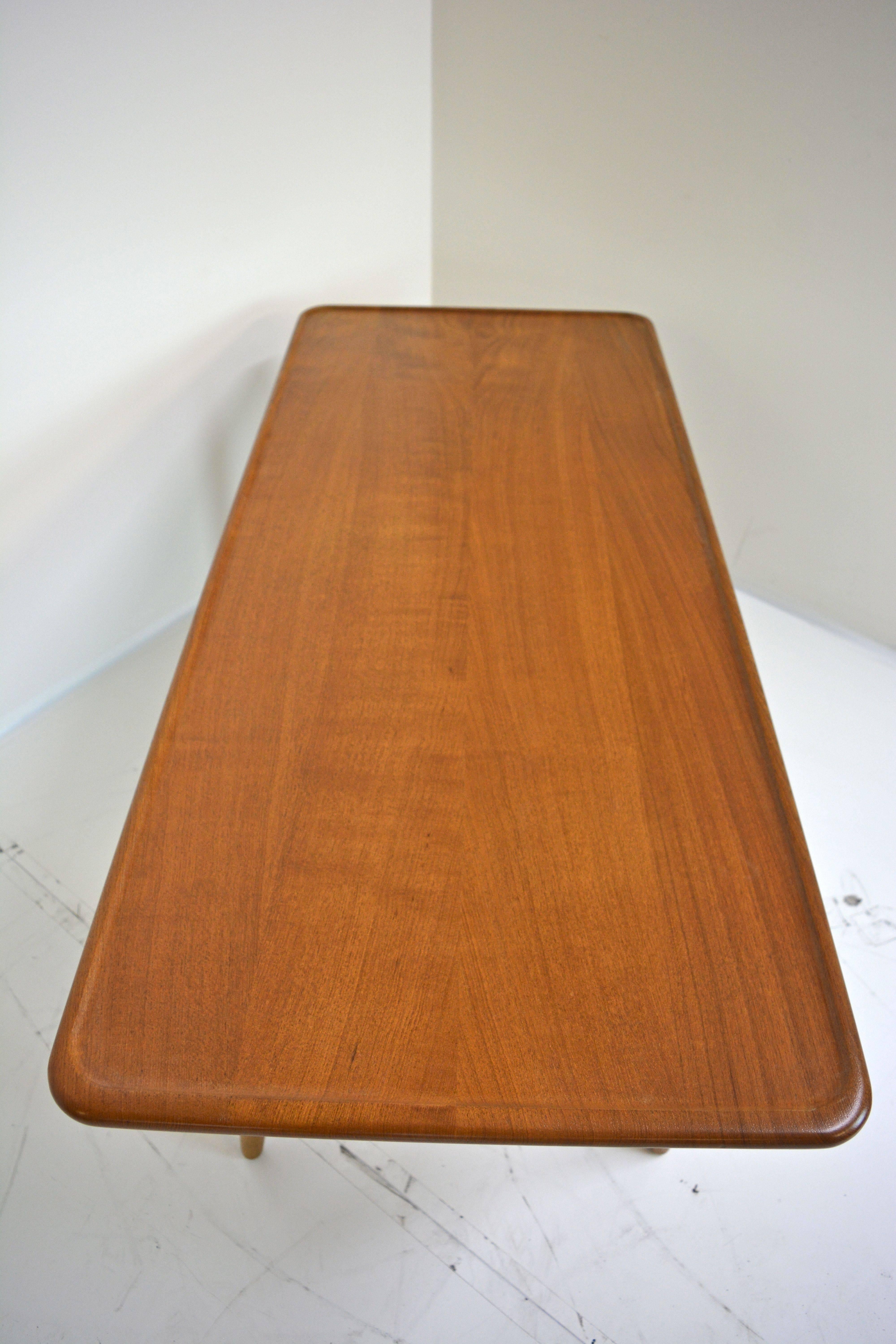 Tall coffee table by Hans Wegner for Andreas Tuck, Denmark, circa 1950s. Solid teak top with defined edge detail. At more than 20 and 1/2