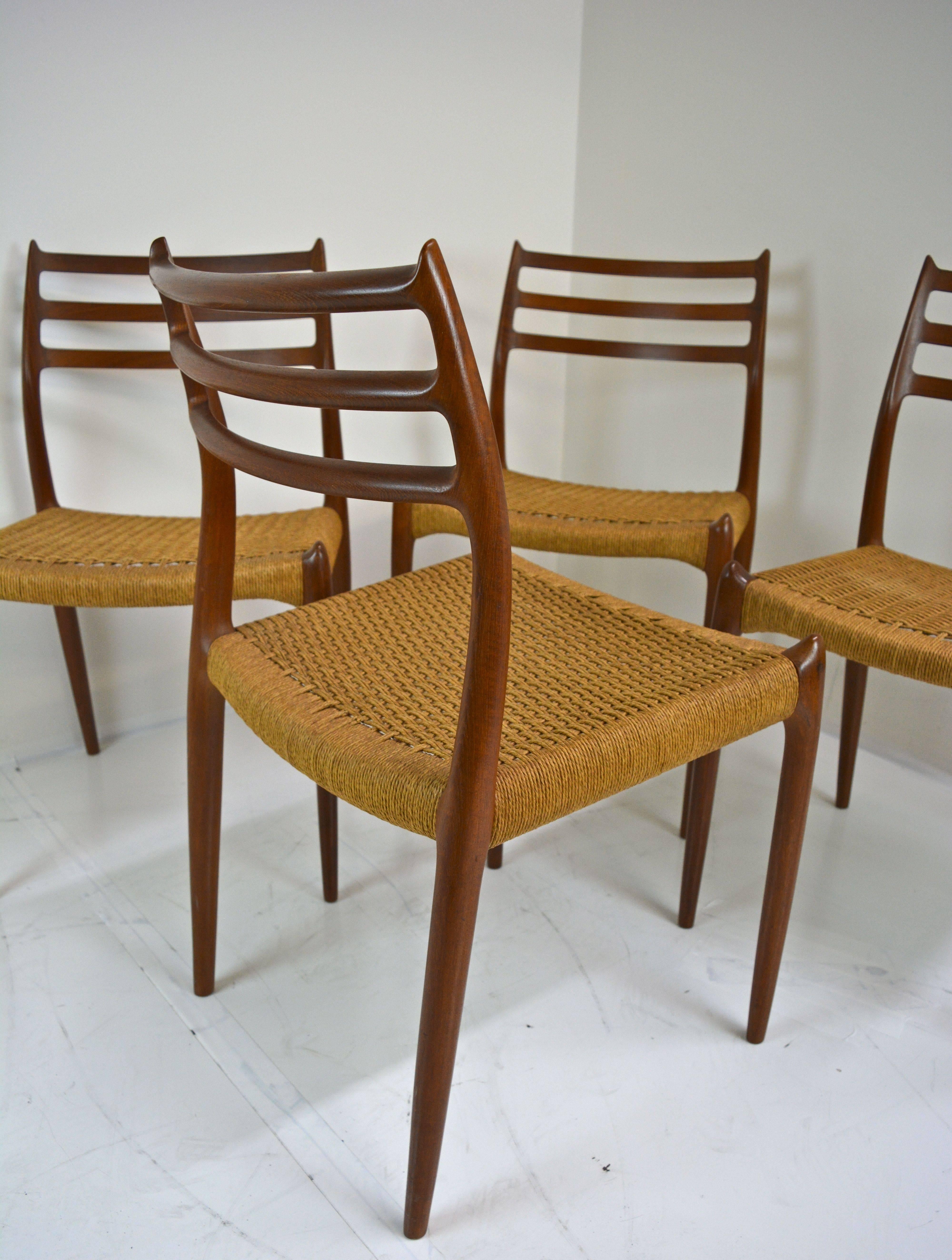 Set of four Danish teak dining chairs, model #78 by N Ø Møller for J L Møller. Excellent original condition. Even three of four original cord seats are perfect. Only one has any wear as shown in images where stress has severed a handful of the