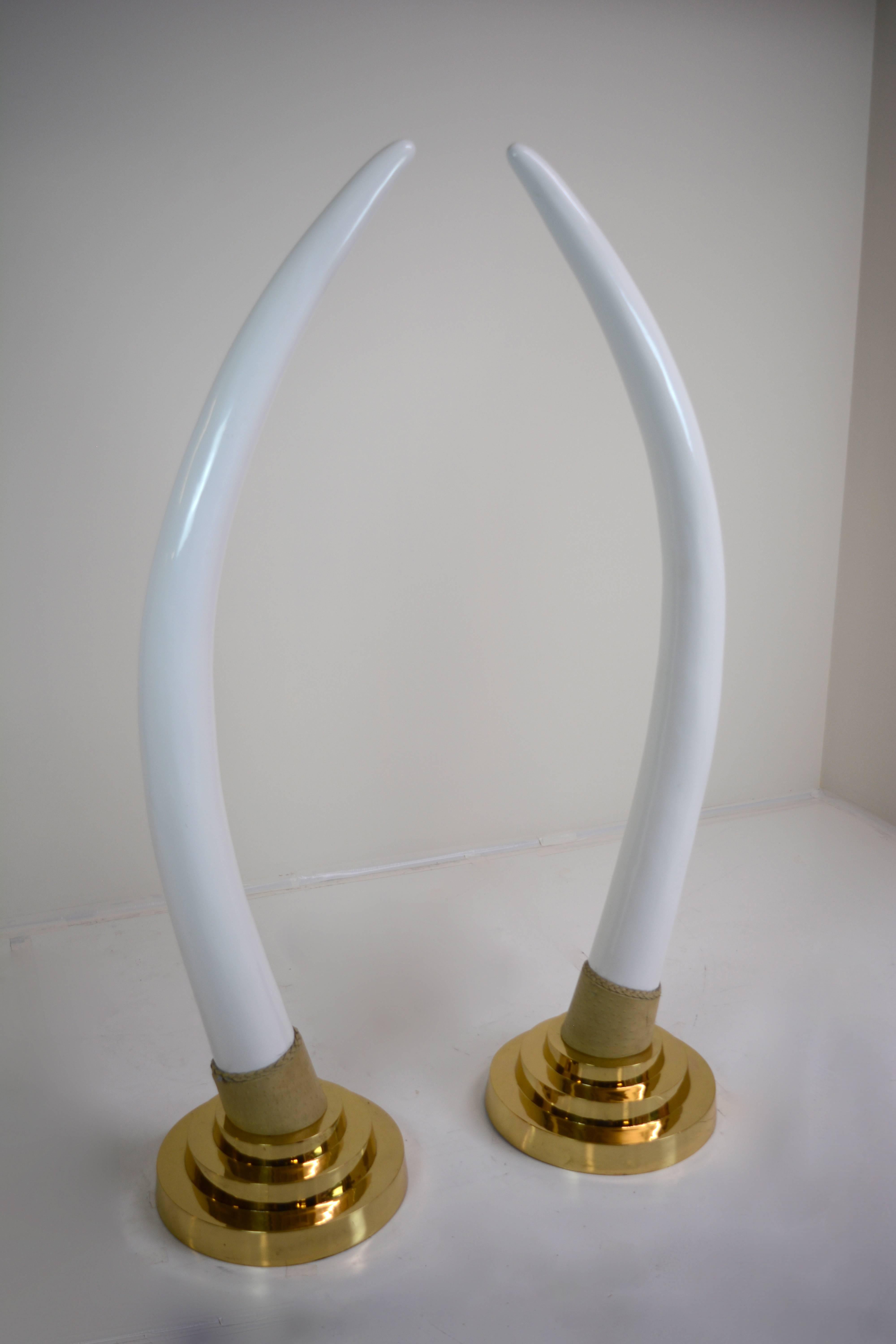 Impressive large-scale faux tusks of enameled brass with solid brass bases and ostrich leather trim, 
circa 1960s.