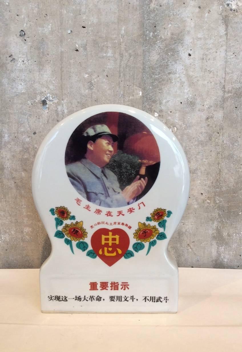 A standing Cultural Revolution period porcelain plaque celebrating Chairman Mao. This plaque is decorated on both sides with an image of a clapping Mao on one side and Cultural Revolution slogans on the back. China, circa 1960s.
KM-9.