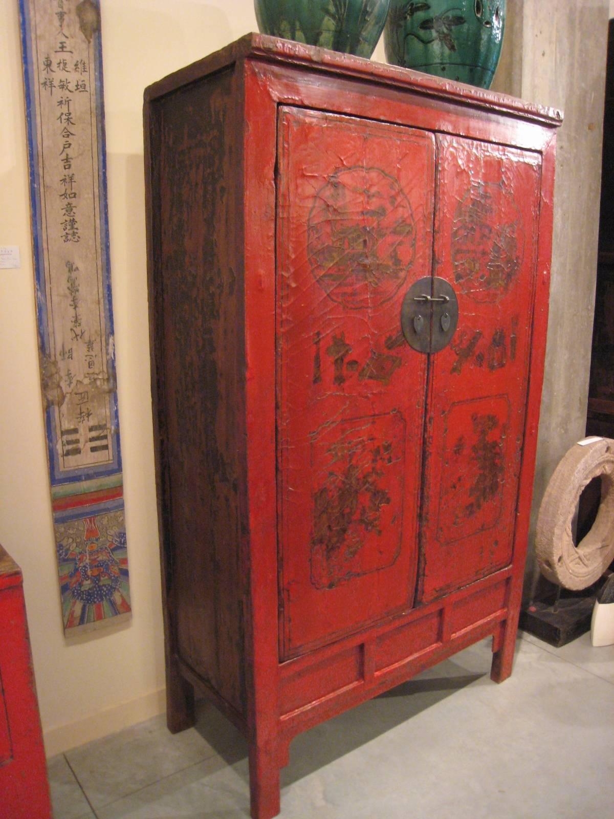 A rare and unusual antique Chinese lacquered cabinet with beautiful, highly detailed painted images on the front.   The striking Chinese red lacquered doors with a snakeskin pattern  contrast perfectly with the remnants of old black lacquer on the