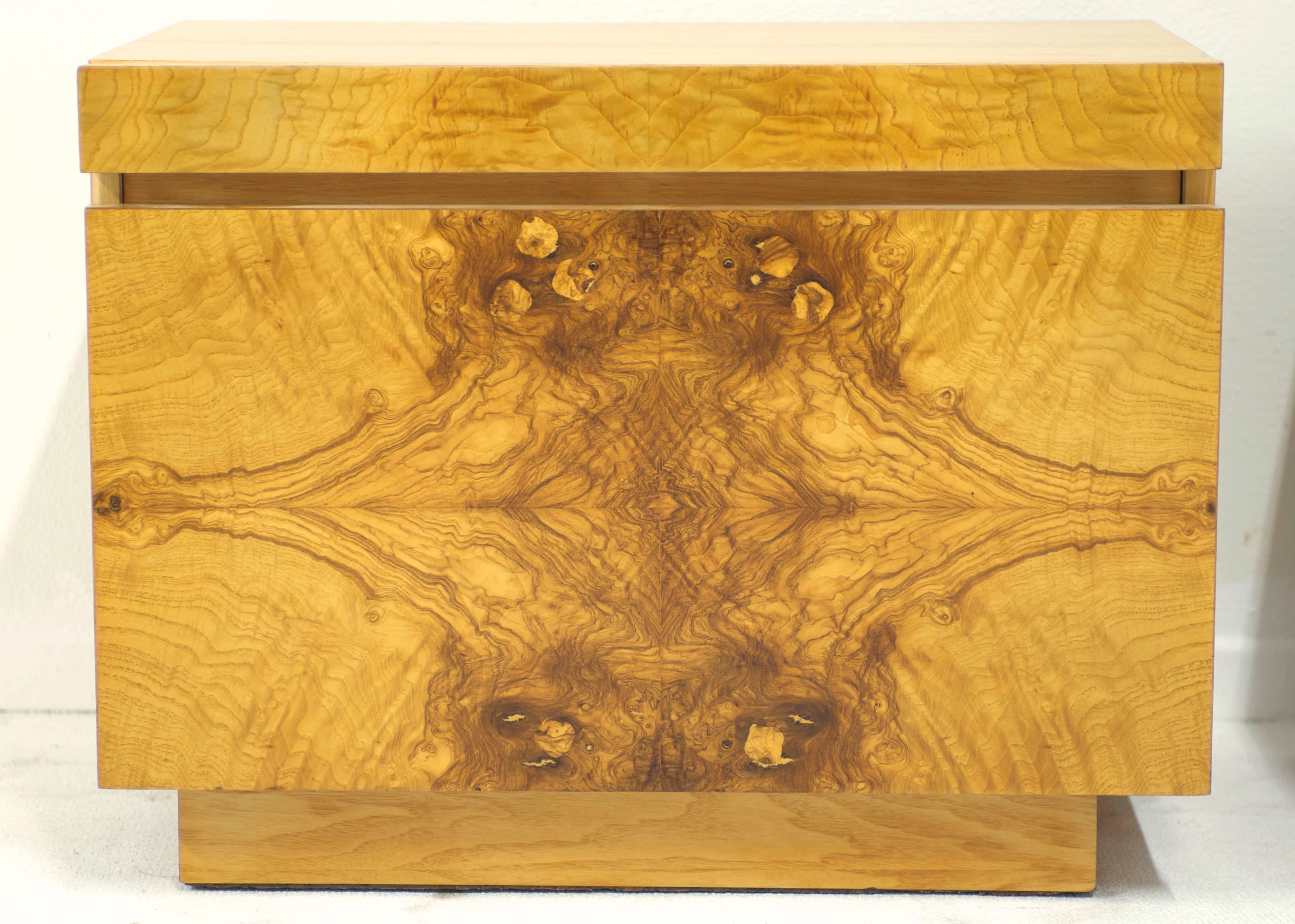 A pair of very nicely figured olive burl wood nightstands designed by Milo Baughman for Lane Furniture Co. They have a pull-out shelf which is topped with a practical white laminate. The top and sides of the bedside tables are made of wood veneer. 