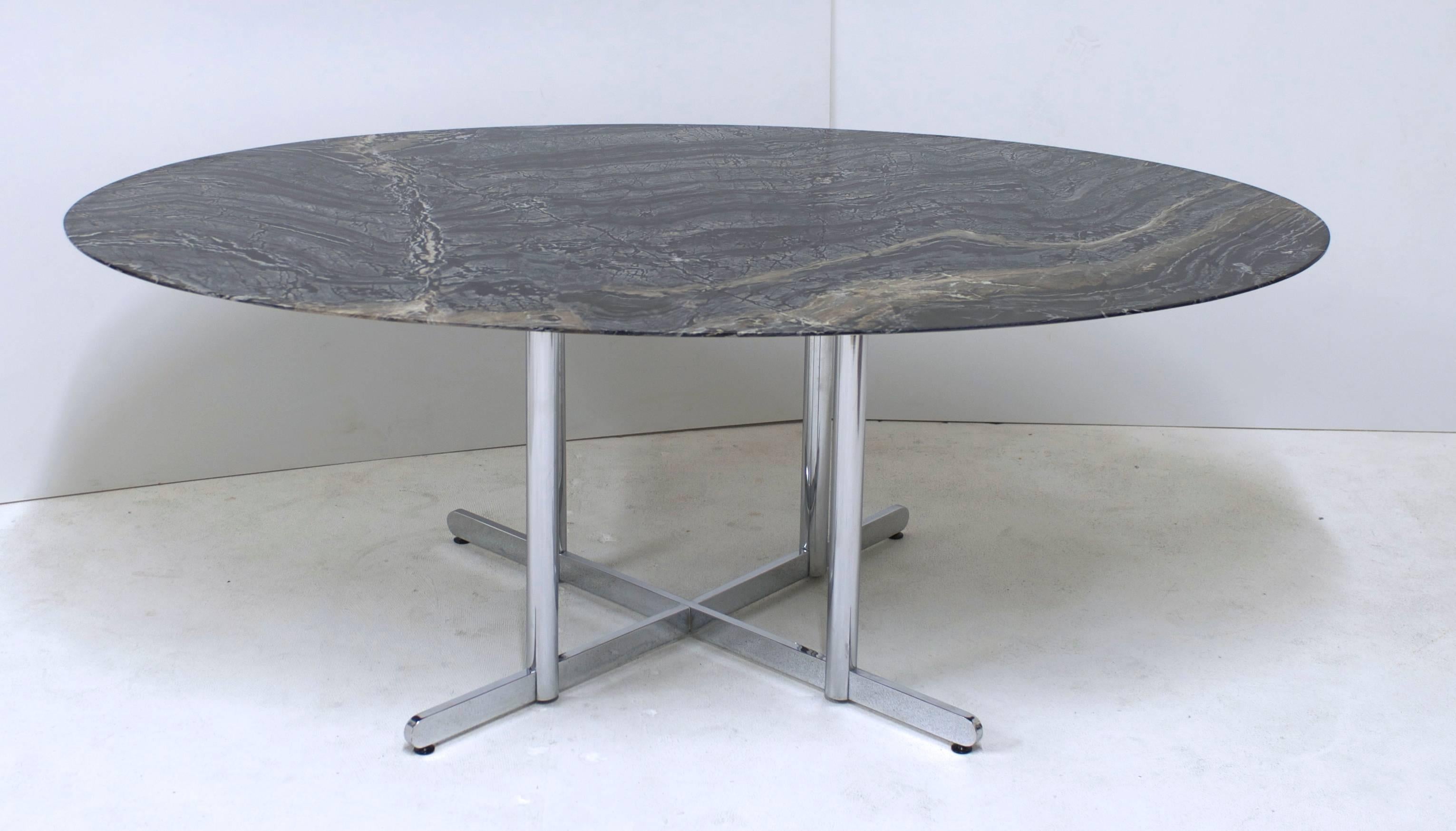 A Knoll style oval marble top with a knife edge. The marble has beautiful veining that looks like petrified wood. The colors are mix of charcoal to deep lava contrasted with some light grey highlights with some brown veining. The stone is set on a