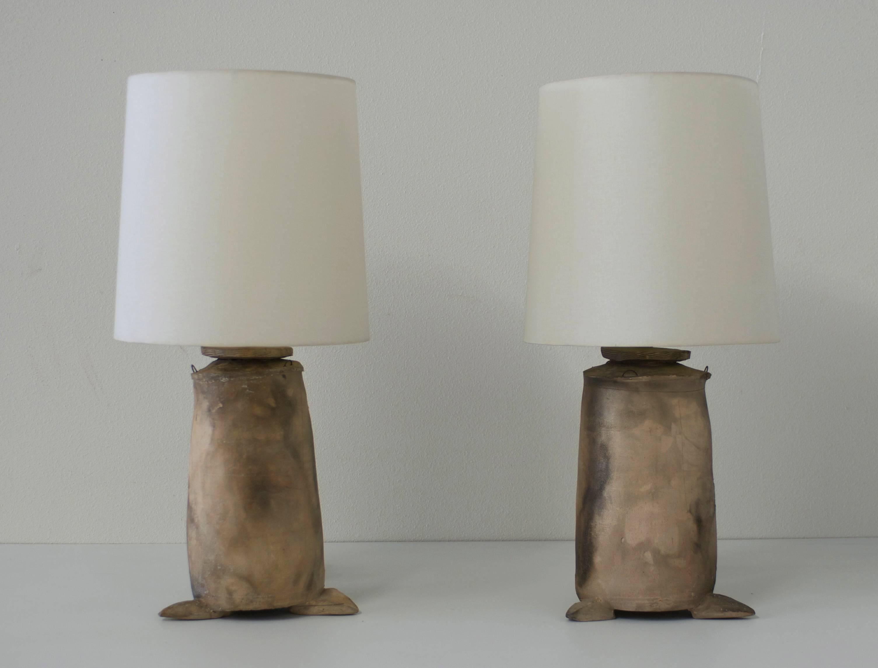 These rustic Japanese influenced raku style earthenware lamps have a smoke and sand colored matte glaze. The handmade ceramic organic shaped lamps sit on three triangular leaf shaped feet. The shades are borrowed from another pair of lamps and were