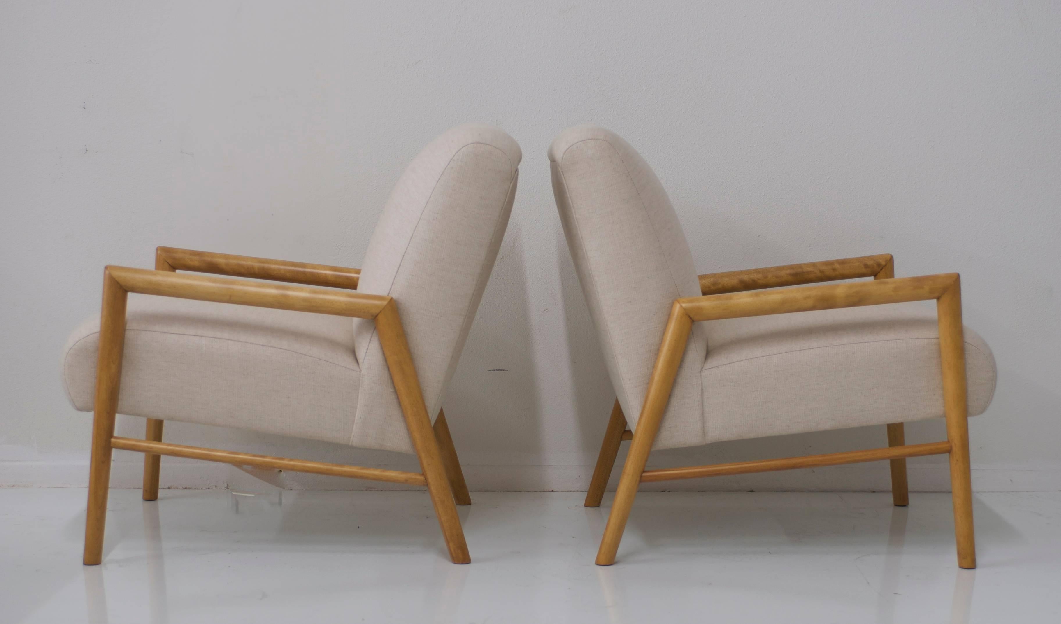 A pair of handsome Mid-Century lounge chairs designed by Leslie Diamond for Conant Ball. The slanted hardwood frame has been professionally refinished to it's original luster. The chairs have been reupholstered in a beautiful sand colored fine