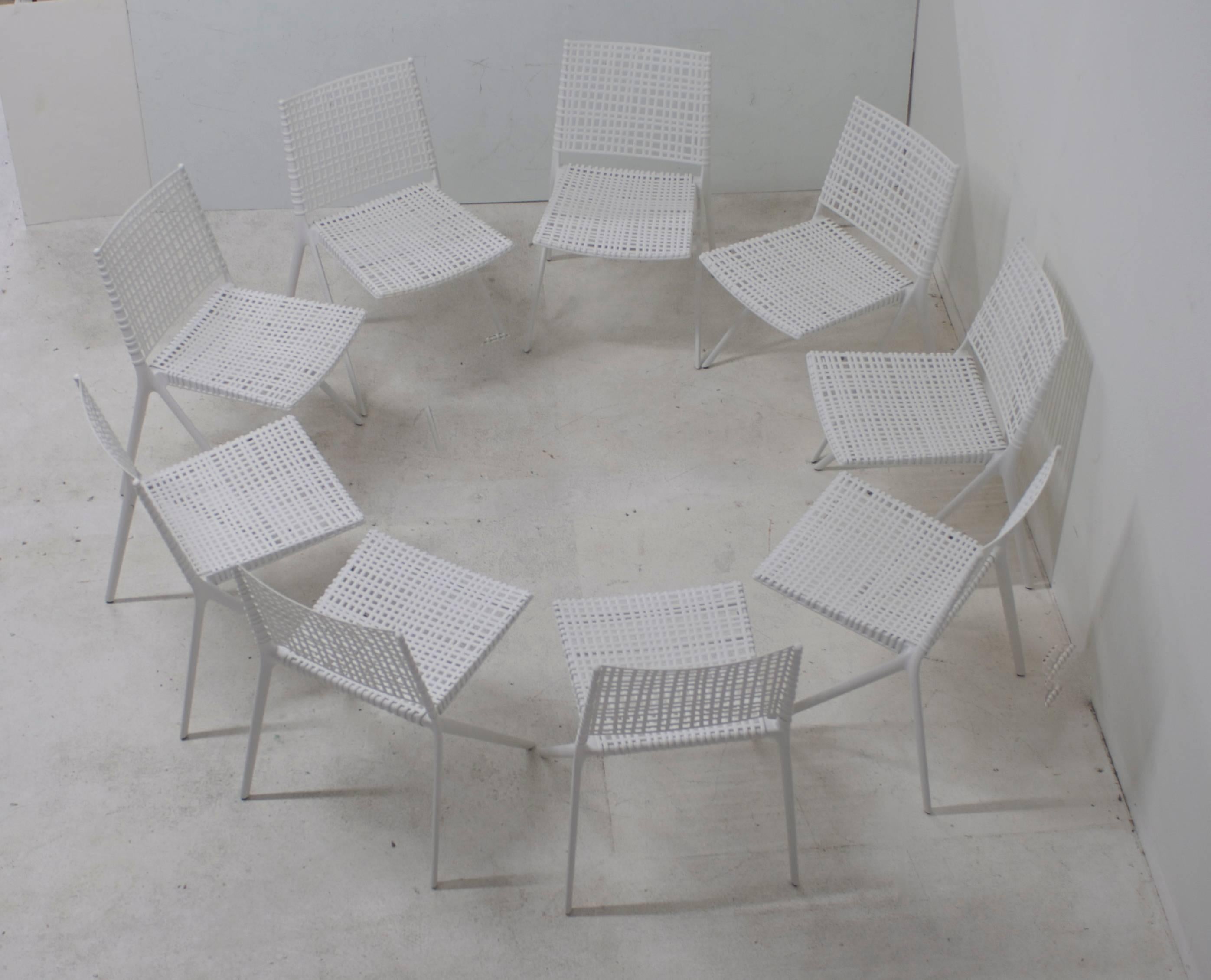 A set of nine white powder coated aluminum outdoor side chairs for dining from the Branch collection by Janus et Cie. 
The seat and back are woven polypropylene and fiberglass.
They are gently used and in excellent condition ready for use in the