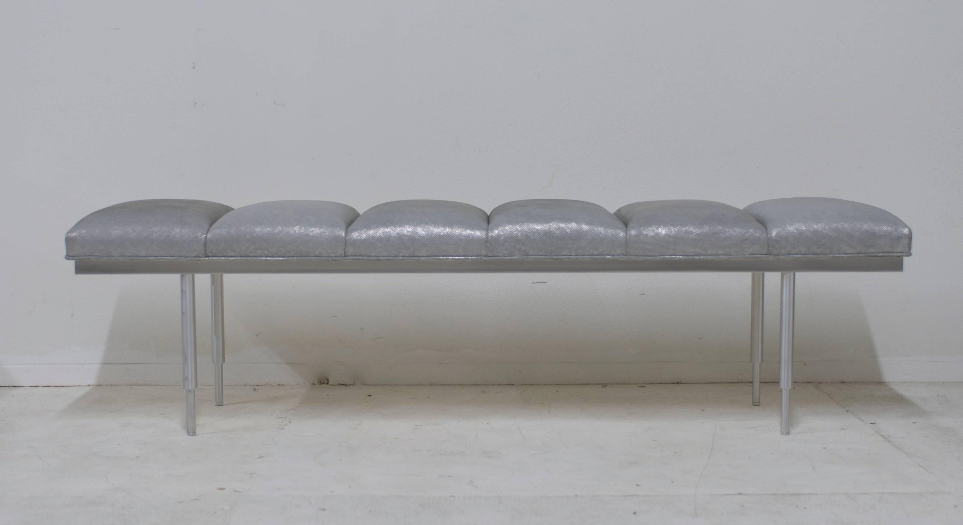 A vintage 1970s brushed aluminum bench that has been reupholstered in a 
luxe soft iridescent textured silver leather. Two more benches available so another could be ordered to match to make a pair.