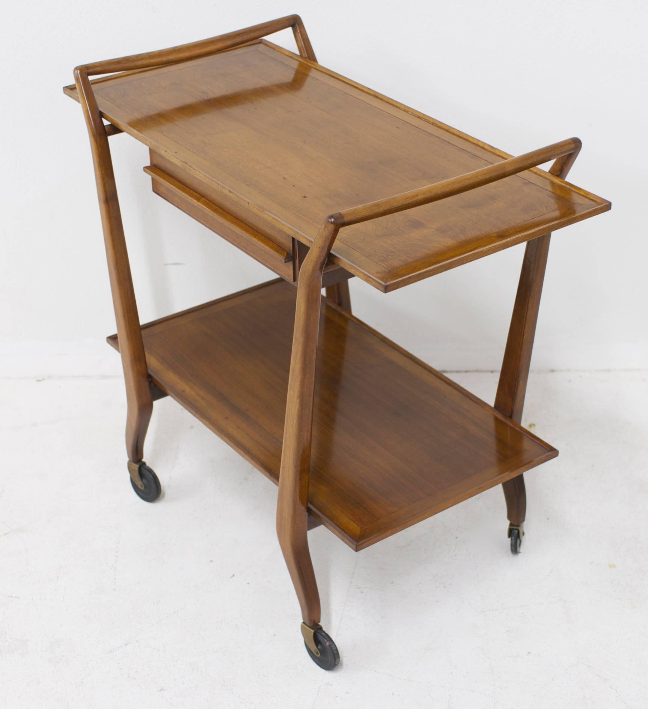 An elegant vintage bar cart made of what appears to be walnut. The two-tiered trolley has a drawer on the top which is accessible from both sides of the cart.
The lower shelf is 12