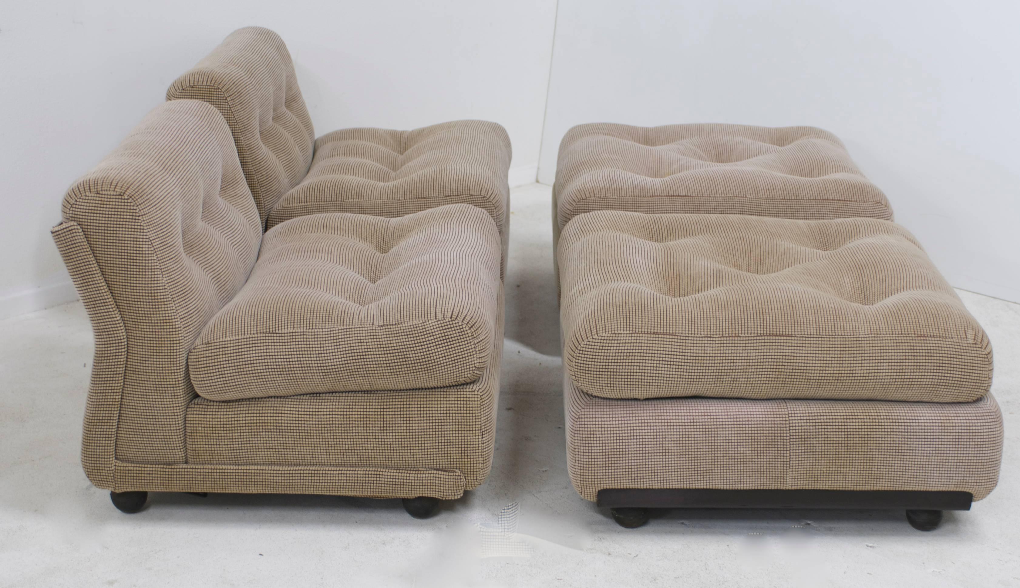 A pair of very comfortable 1970s era Amanta lounge chairs and ottomans designed by Mario Bellini and manufactured in Italy for B&B Italia. The fiberglass form is covered in the original fabric, a fine cut velvet micro grid dot pattern which has been