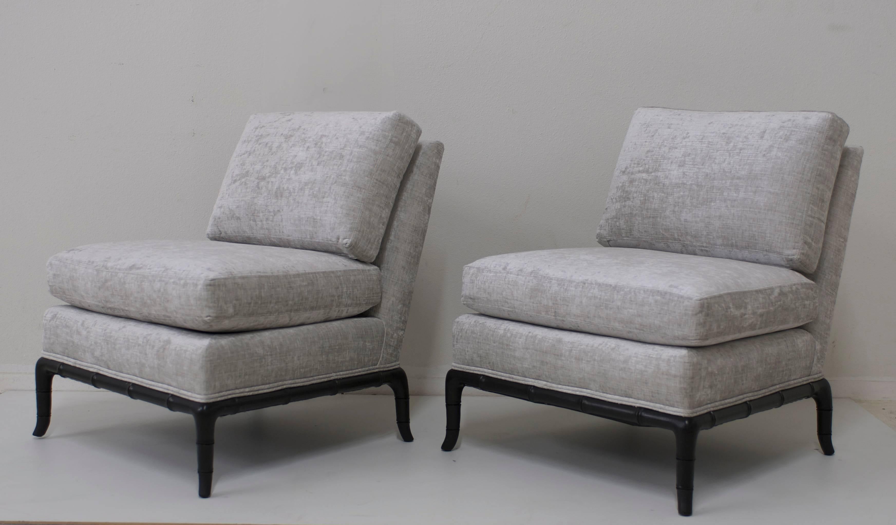 This pair of slipper chairs have been reupholstered in a nice silver gray platinum velvet. The base is carved faux bamboo ebonized wood. The legs are horn shaped.