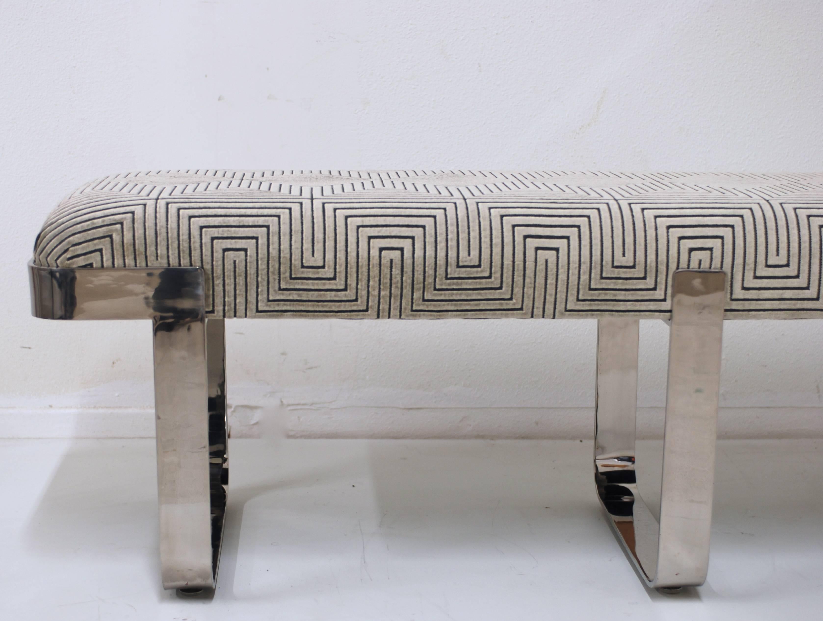 This vintage 1970s era Mid-Century Modern bench has been freshly upholstered in a luxe cut velvet. The geometric pattern has a raised platinum silver velvet on a grey background. The polished chrome base is in excellent vintage condition with only