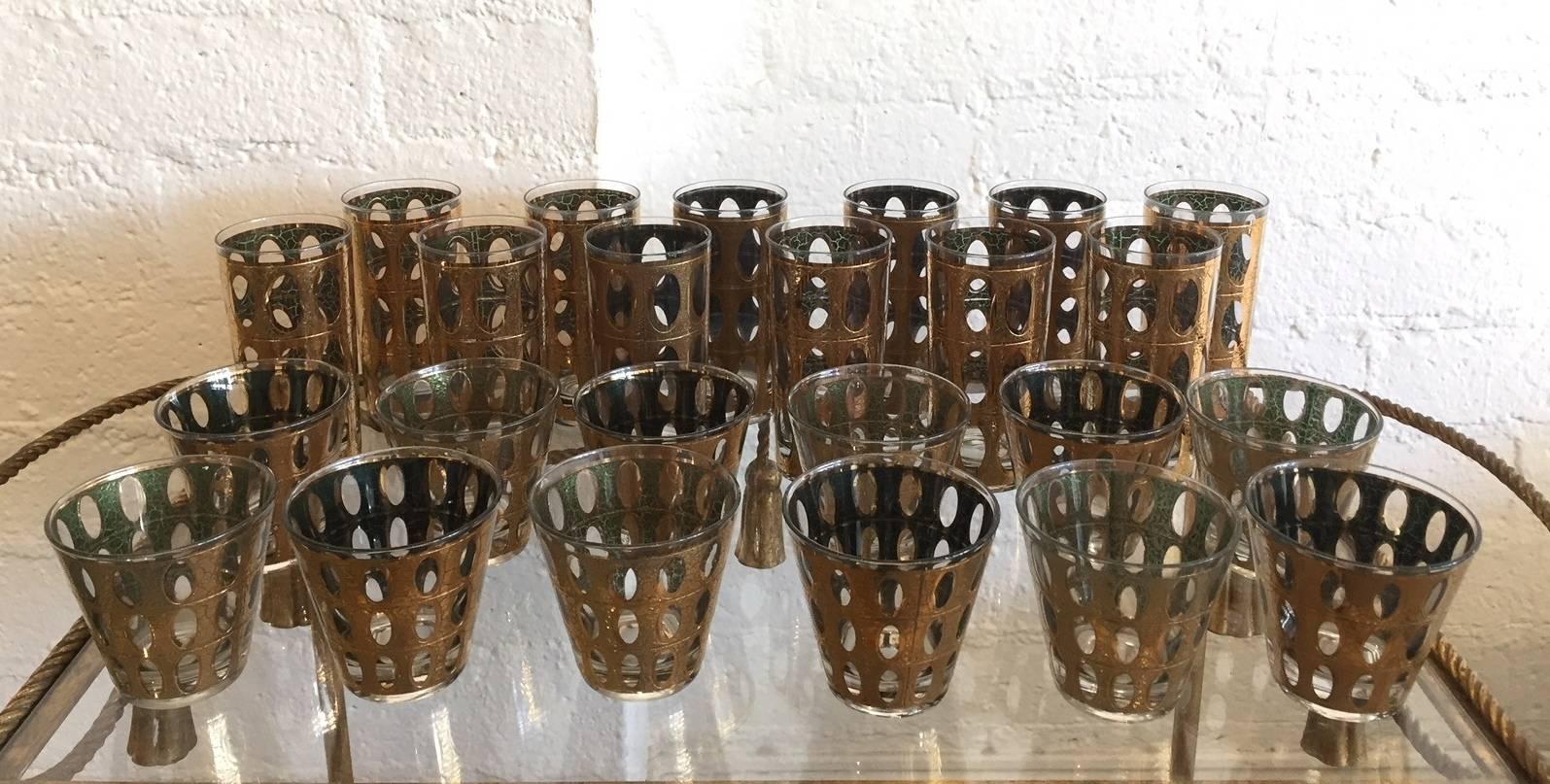 A set of signed 22-karat gold Culver cocktail glasses comprised of 12 high ball glasses and 12 low ball or whiskey glasses. They are in excellent vintage condition. They do need to be hand washed. The tall glasses measure 5 5/8