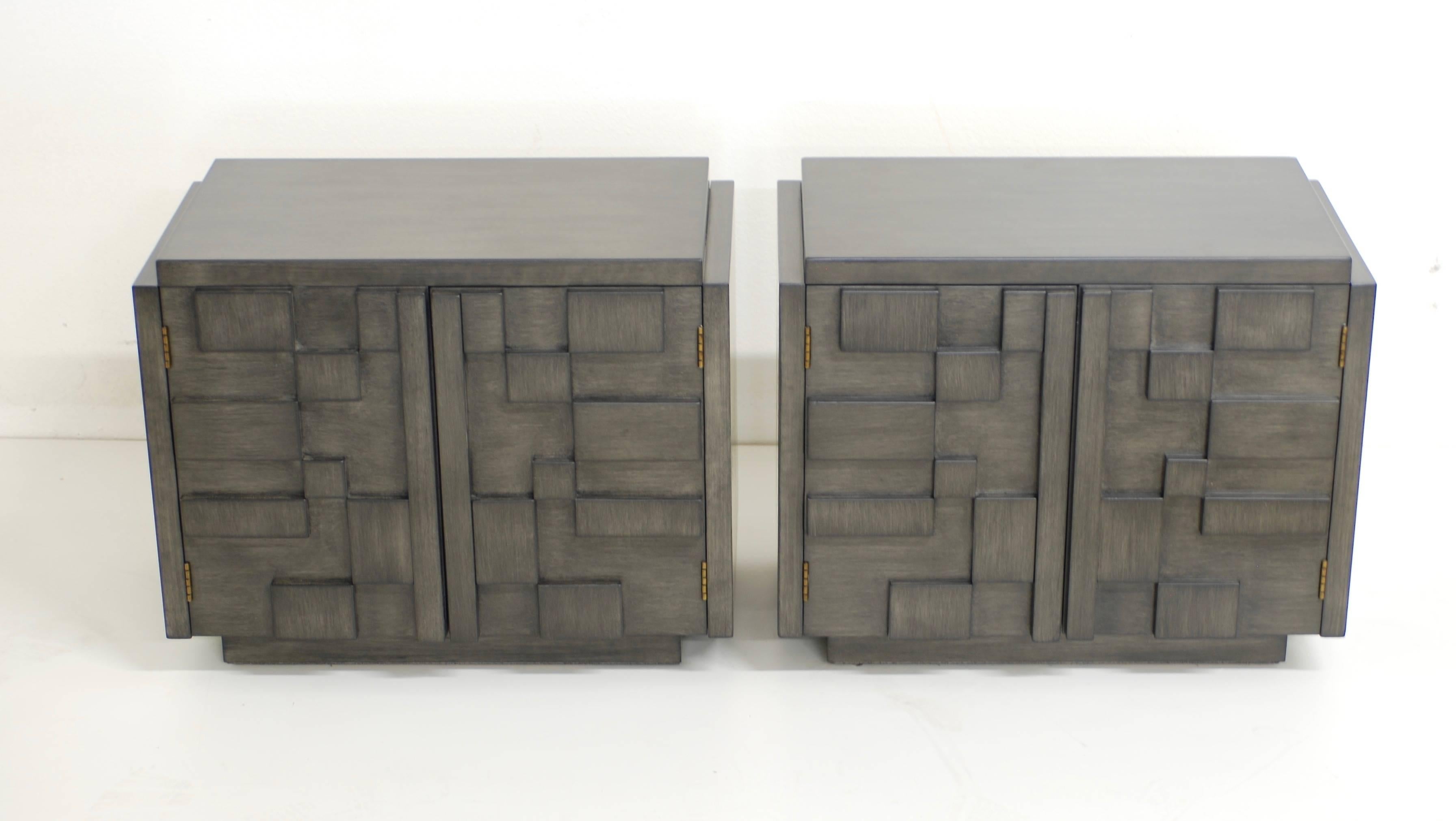 These nightstands manufactured by Lane from the Mosaic line have a handsome Brutalist geometric pattern on the door fronts. They have been refinished in a multi layered charcoal grey finish which has a ashy grey undertone and then a brushed charcoal