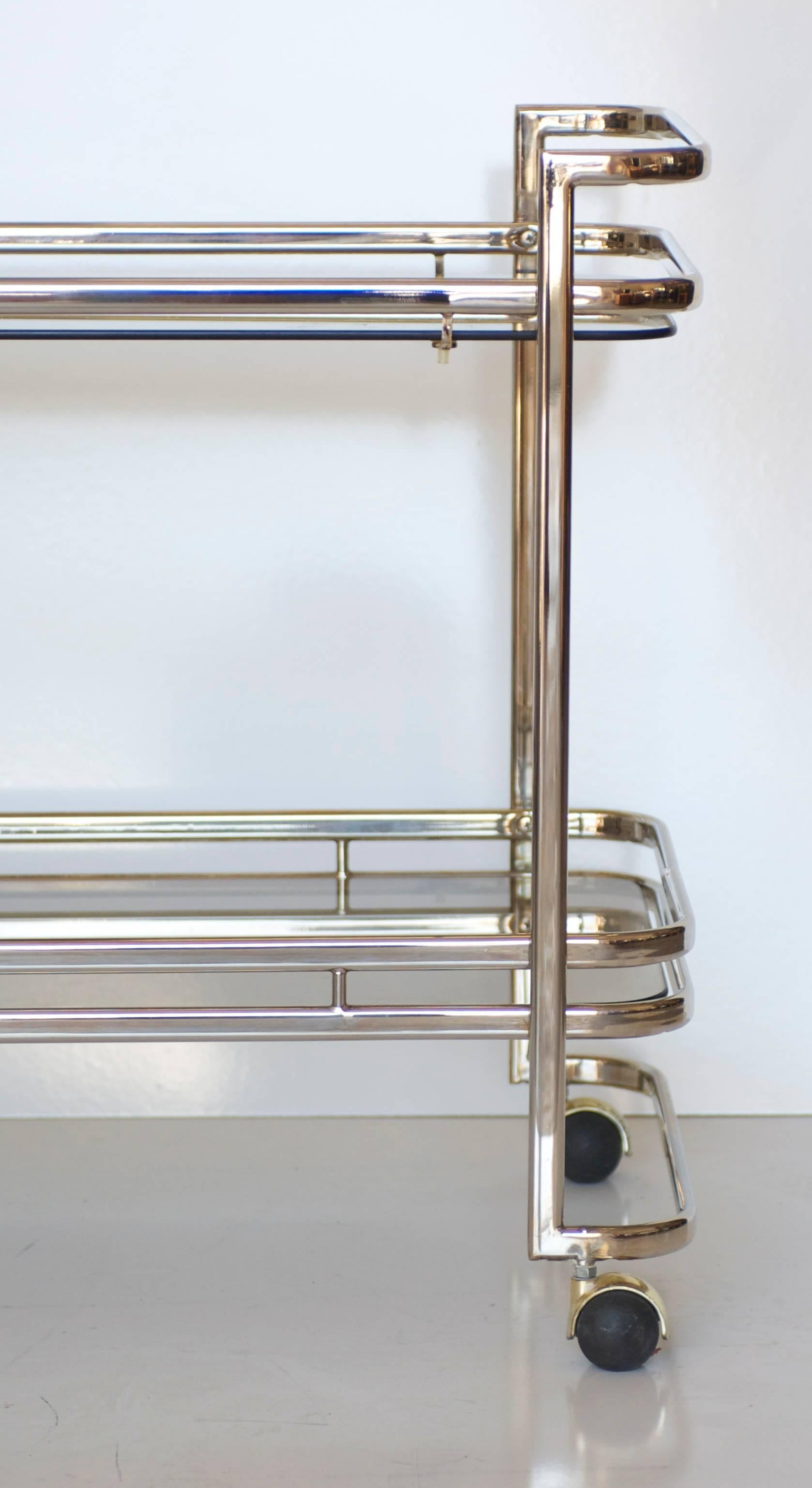 A two-tiered vintage chrome bar cart with two removable glass shelves.
