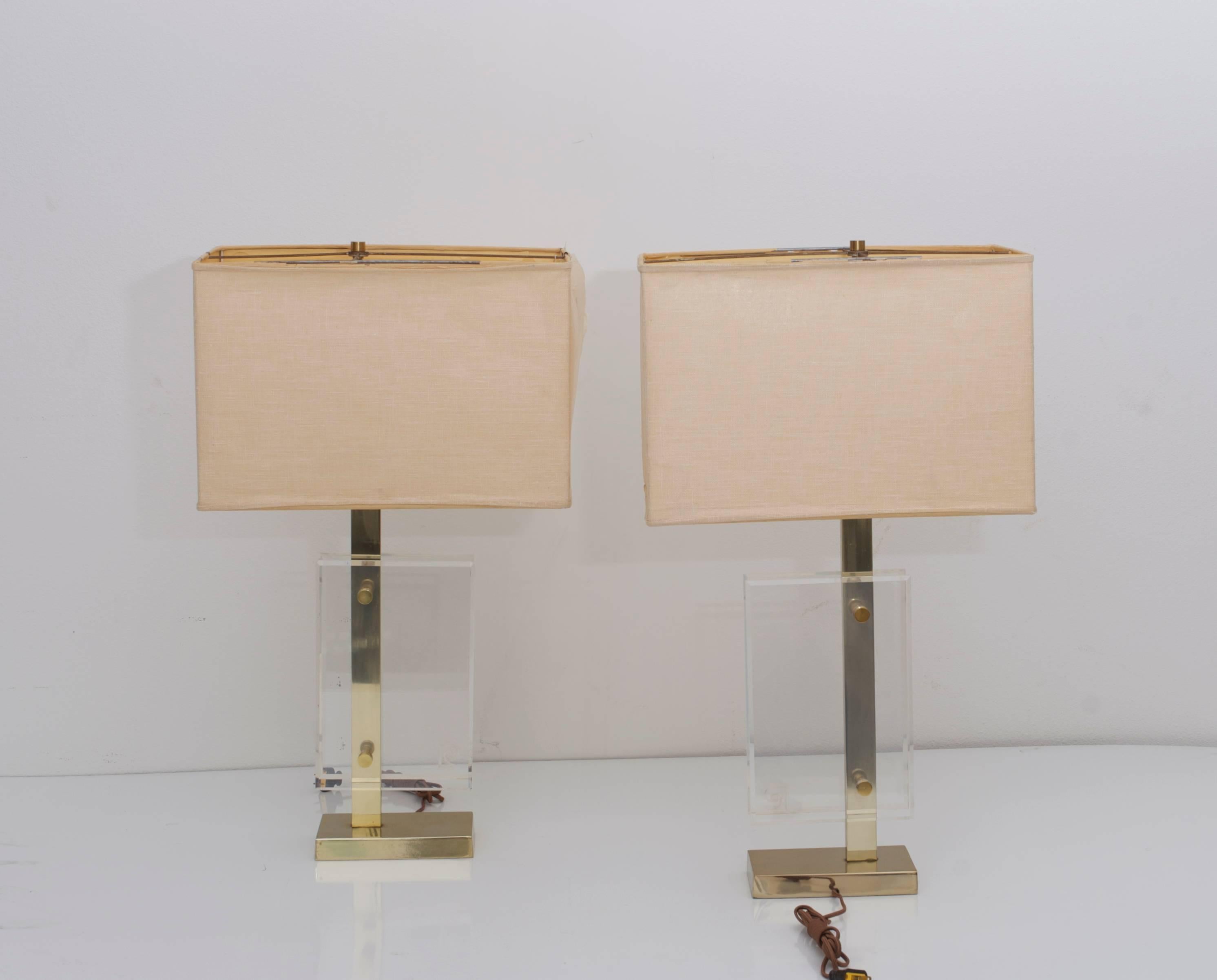 Pair of table lamps in brass and Lucite by Pierre Cardin, the beveled acrylic panels separated by the stem. One panel on each lamp marked with Cardin's 