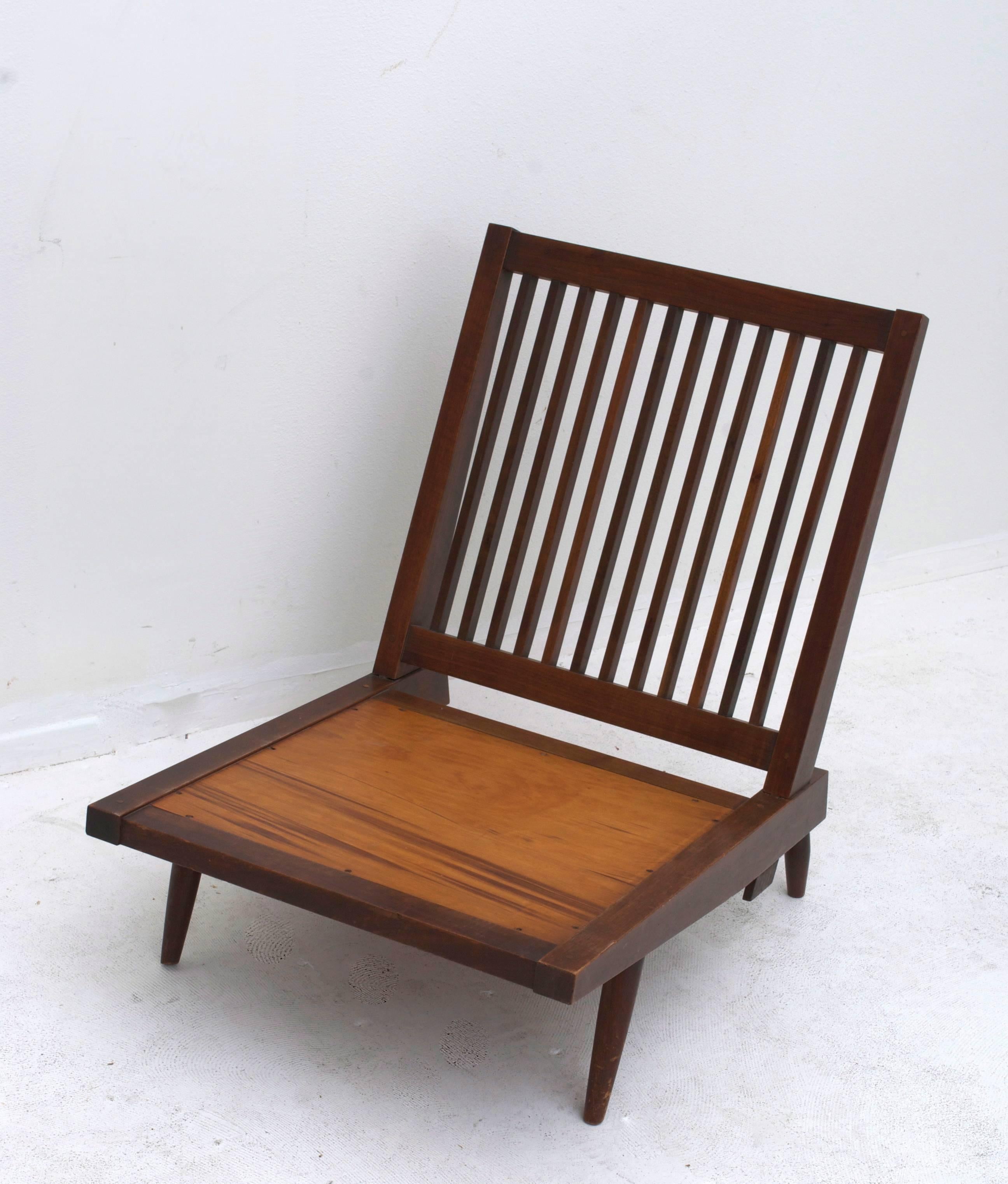 A George Nakashima walnut spindle back chair made with mortise and tenon joinery.

 