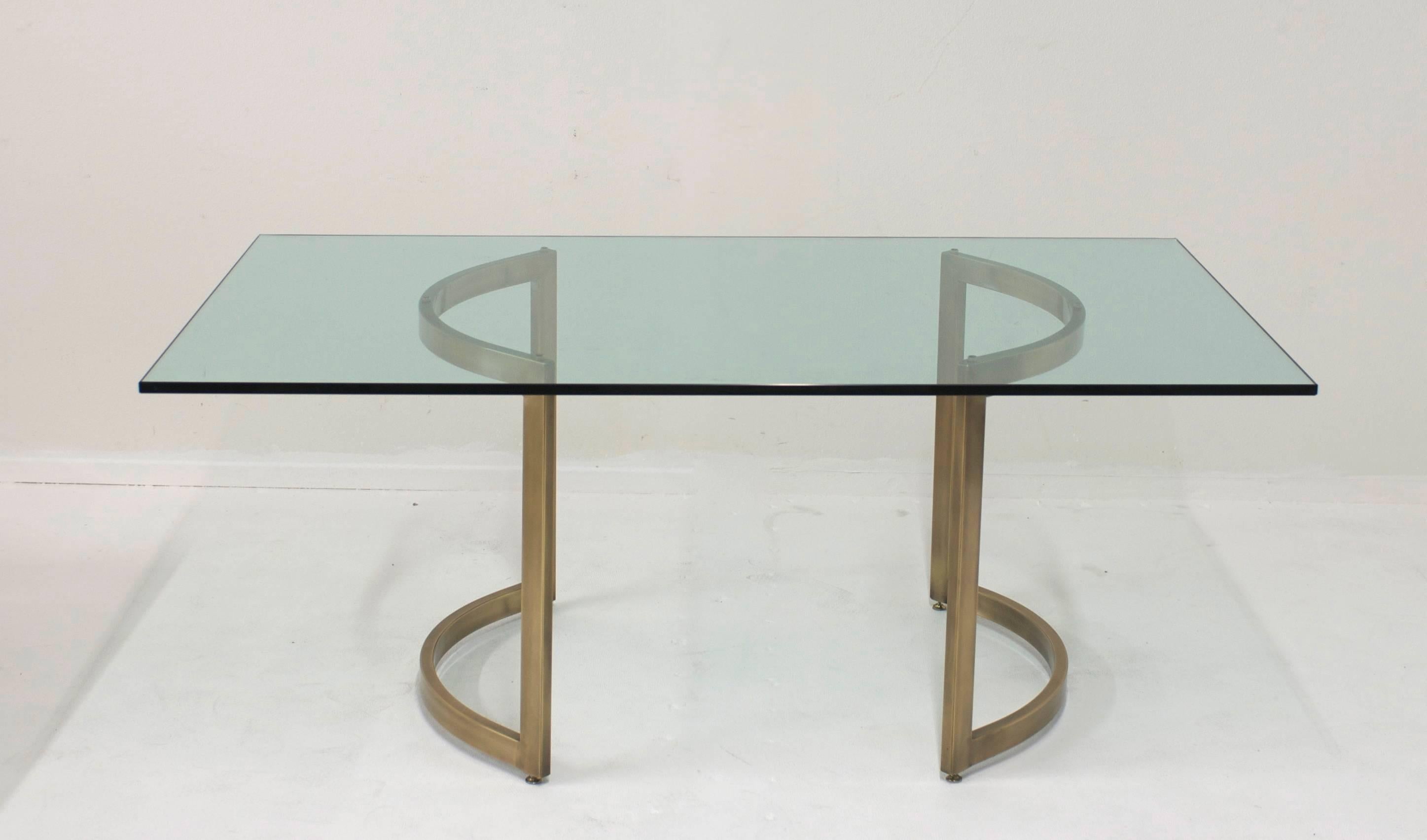A dining table base designed by Milo Baughman (American B. 1923 - 2003) that has been plated in a warm burnished brass. The demilune shaped bases can be configured in a variety of ways. They can face each other to create a circle and could accept a