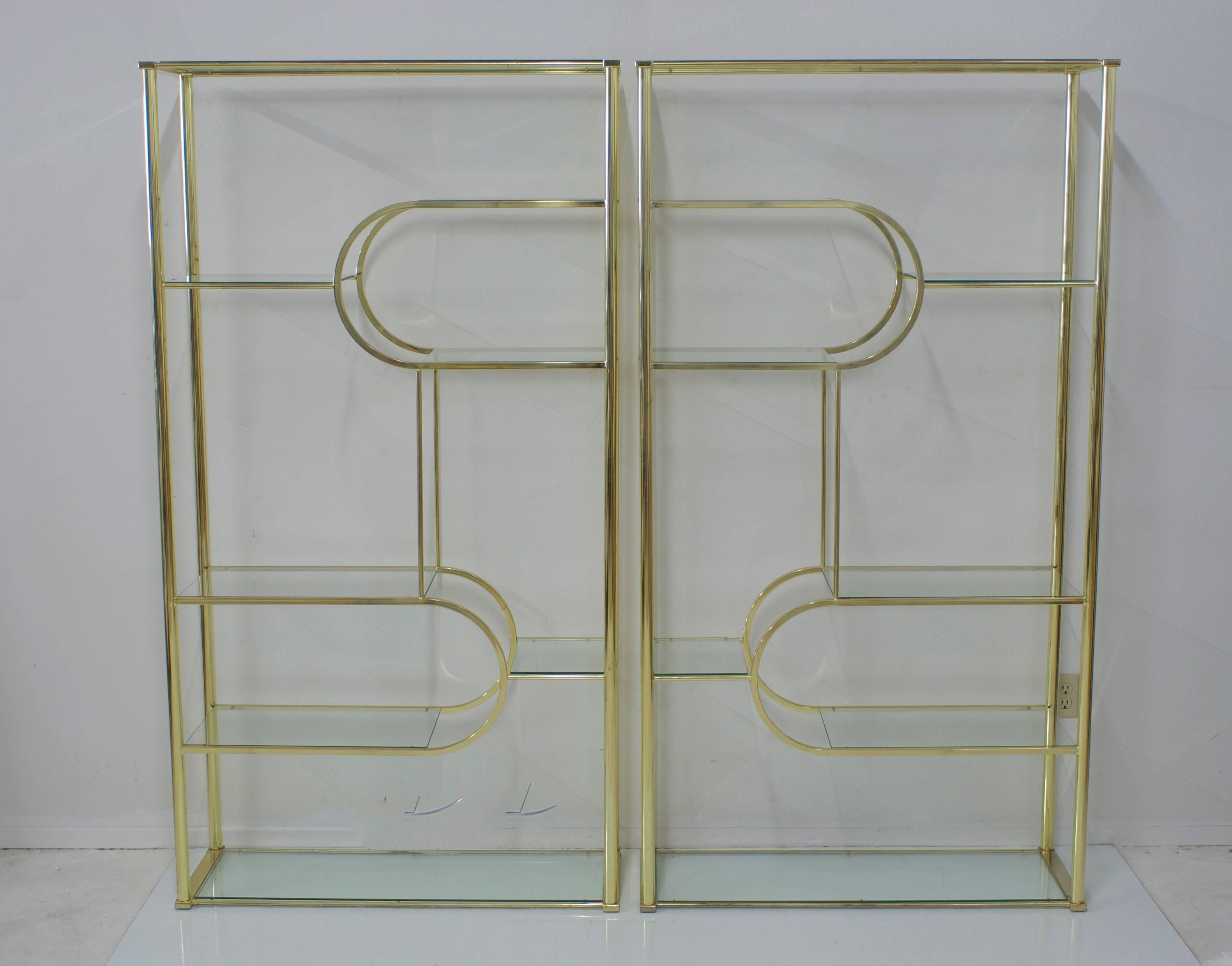 A sculptural pair of etageres or room dividers that create different geometric patterns depending on which ends you push together. They also look great on their own. There are eight glass shelves on each unit including the top and bottom. We have