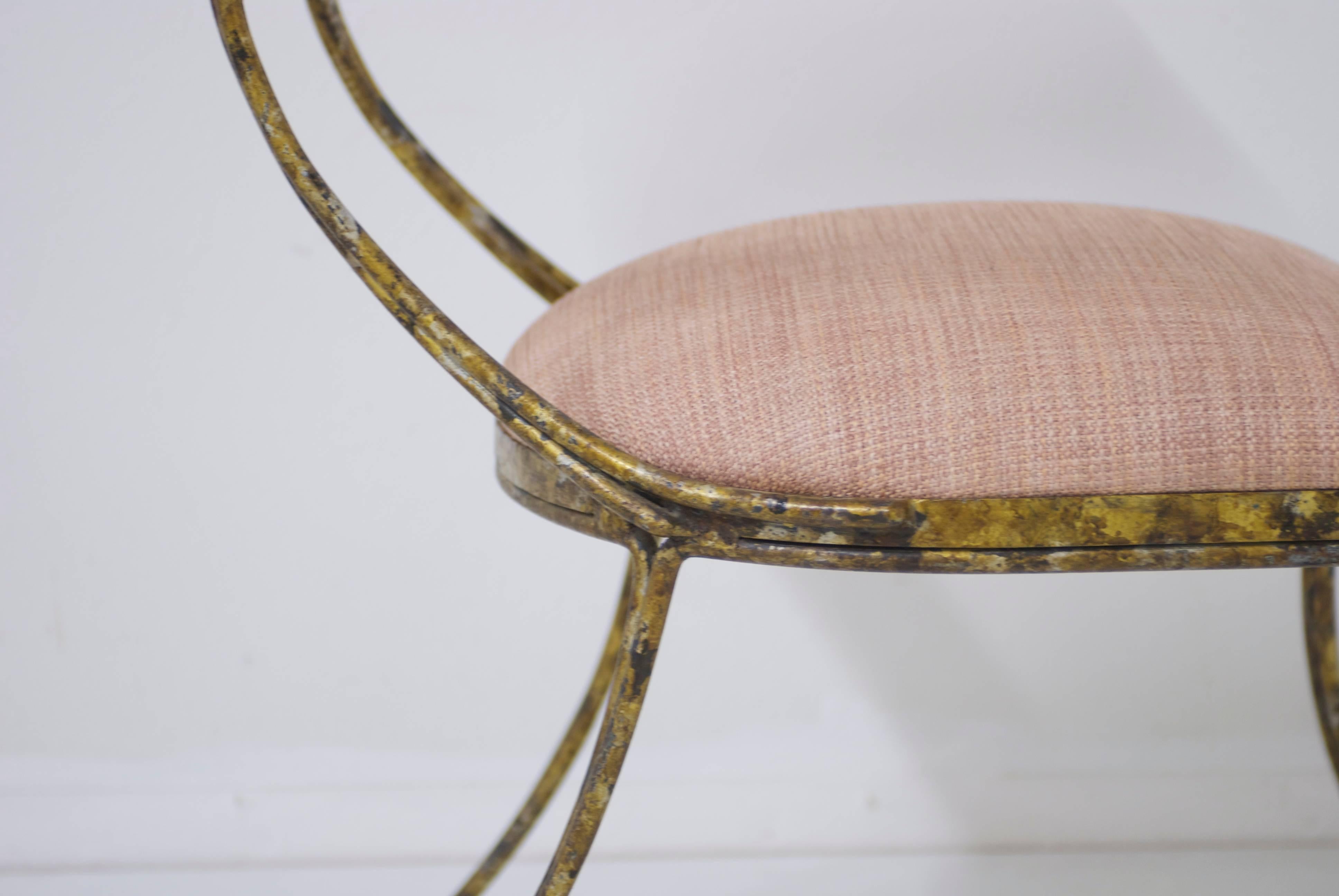 The gilded metal on this handsome chair has beautiful mixed metal tons of gold, bronze and charcoal. The chair has been upholstered in a soft blush pink upholstery fabric.
 