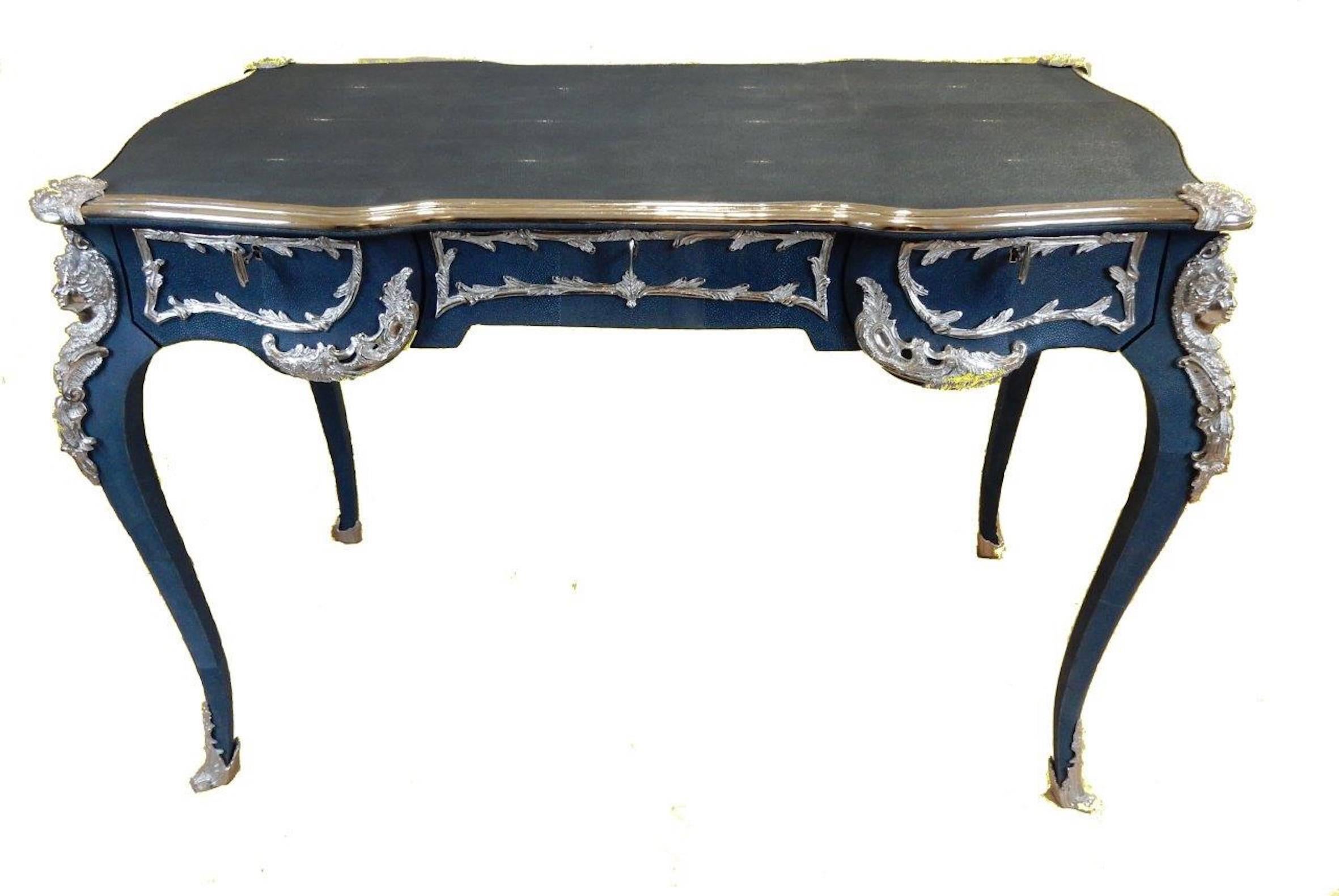 A Shagreen and Nickel plated Bureau Plat

A Louis XV-style blue stained shagreen (stingray skin) and nickel plated Bureau Plat, serpentine shaped rectangular top above three frieze drawers and false drawers on the other side, on cabriole legs