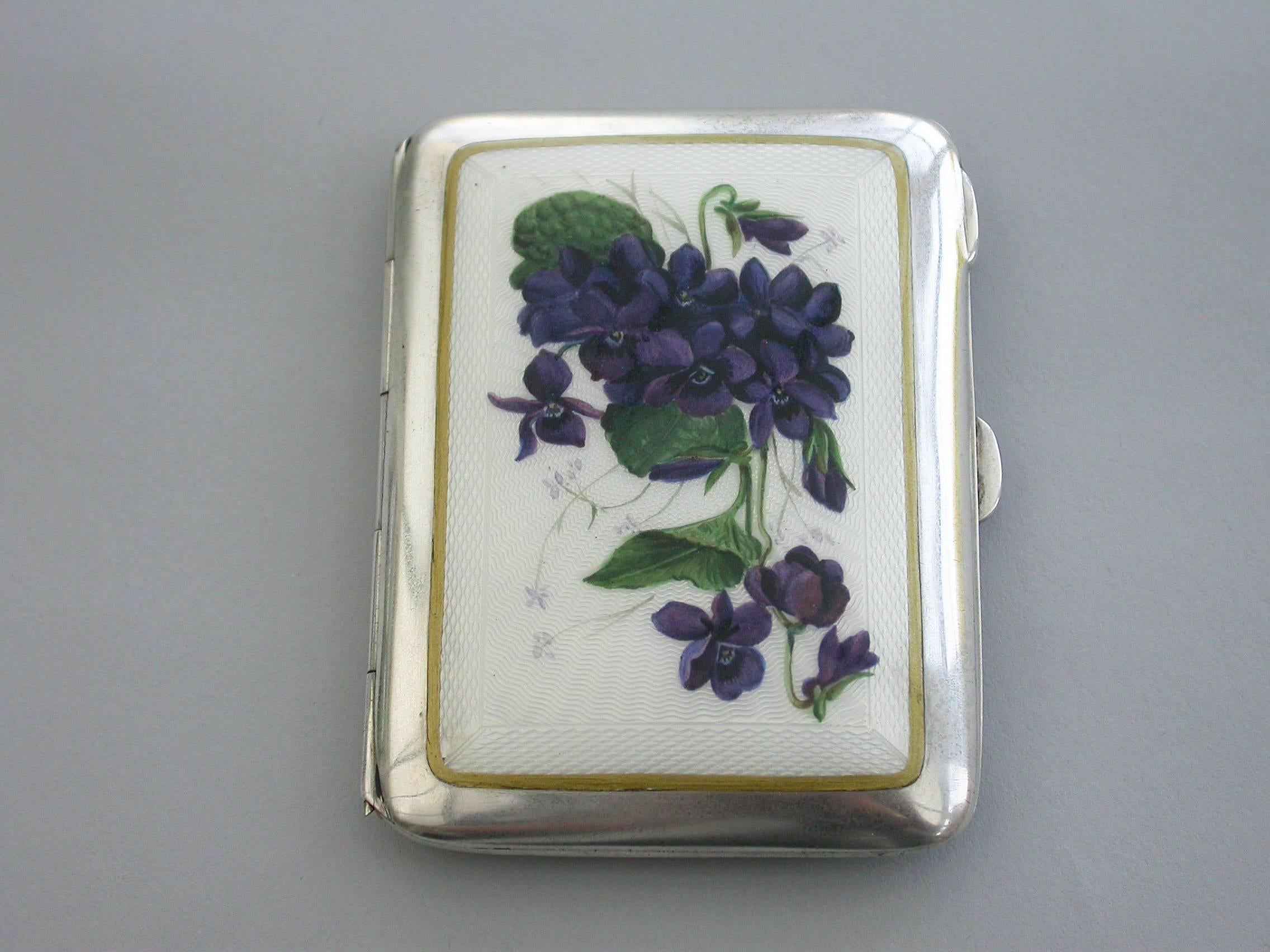 An early 20th silver cigarette case of curved rectangular form, the lid with inset guilloche enamel panel painted with sprays and violets. Silver gilt interior.

By Charles S Green & Co, Birmingham, 1915

In good condition with no damage or