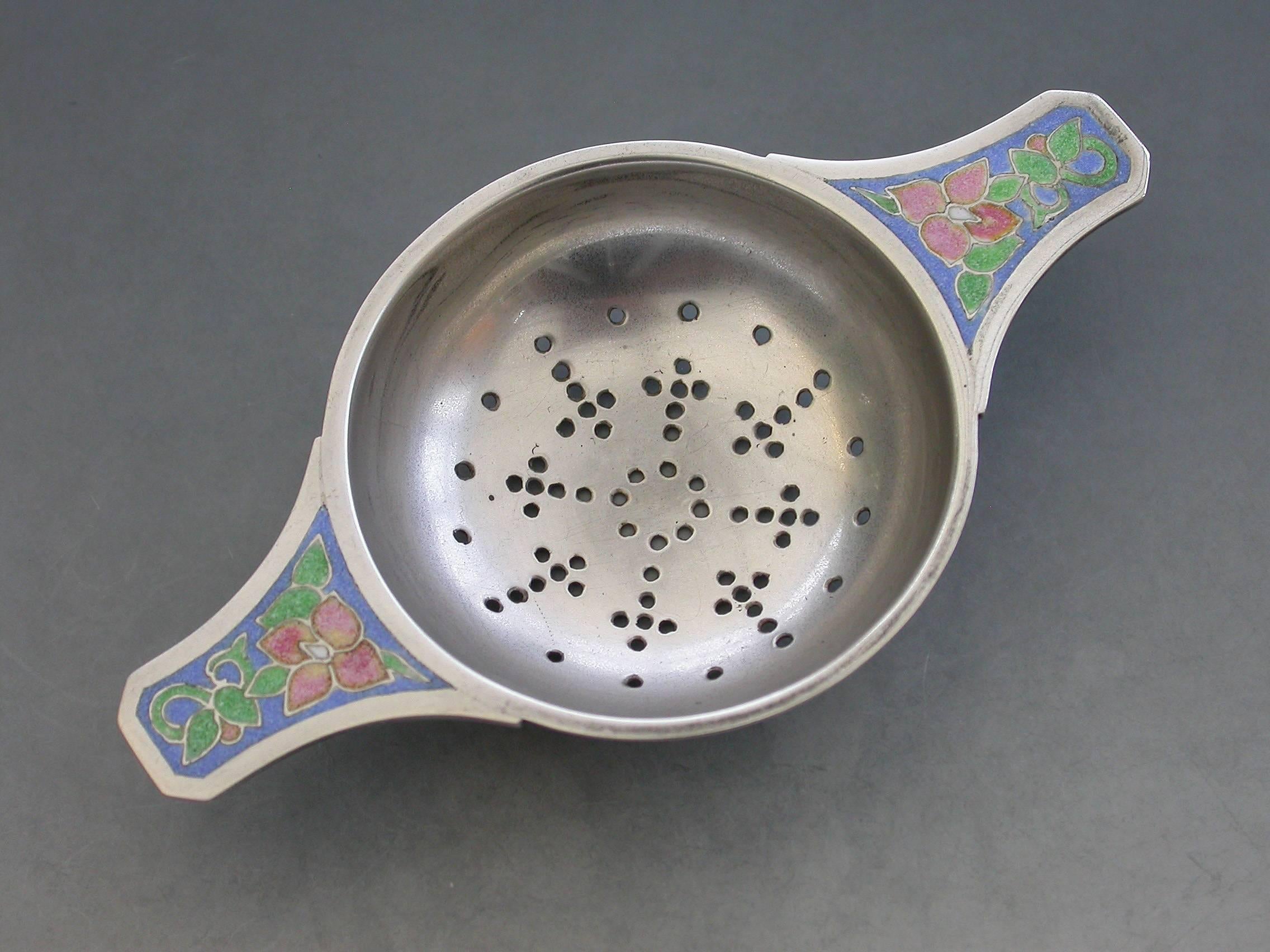 A good early 20th century silver tea strainer made in the Arts & Crafts style, the two lug handles inset with colorful enamel flowers on a blue ground.

By Bernard Instone, Birmingham, 1930.

Also signed with facsimile signature.

In good