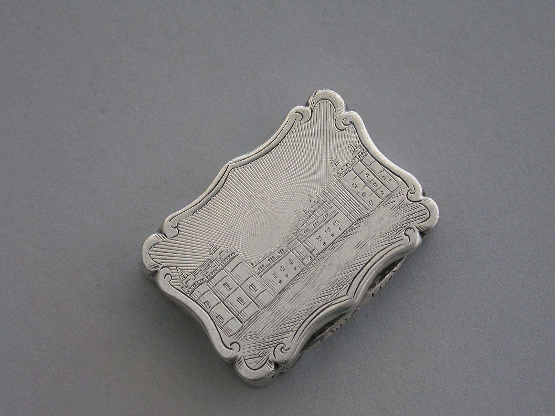 A rare Victorian silver Vinaigrette of shaped rectangular form, the base and sides with bands of engine turned decoration and a vacant shaped cartouche. The lid engraved with a scene depicting Holyrood House in Edinburgh, Scotland. The silver gilt