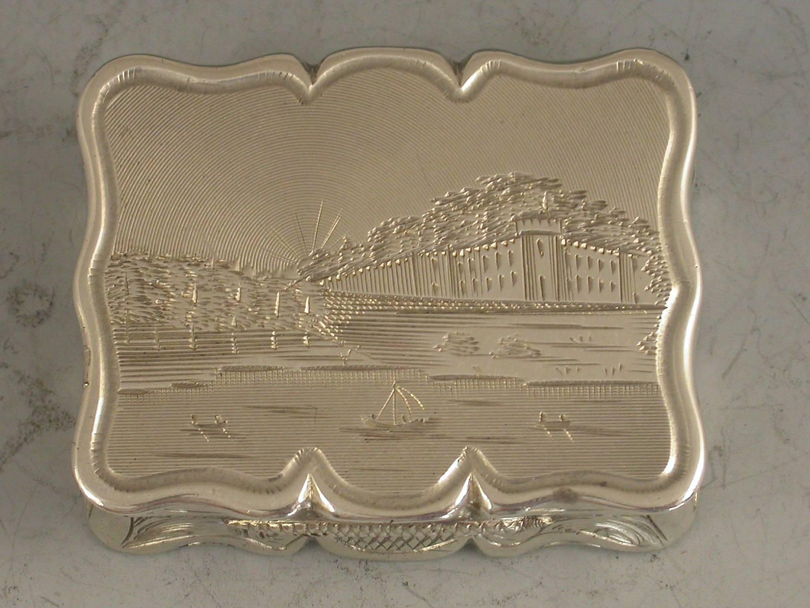 A rare Victorian silver Vinaigrette of shaped rectangular form, the base engraved with scrolls and a cartouche with presentation inscription, the lid engraved with a scene depicting an unidentified castle or stately home with a lake in the
