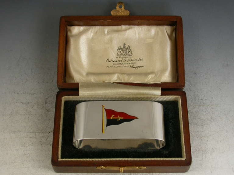 A fine quality early 20th century cased silver and enamel presentation napkin ring with sailing interest, of compressed oval form, the front enamelled with a red and black burgee with gold anchor for the Mudhook Yacht Club in Scotland. The reverse