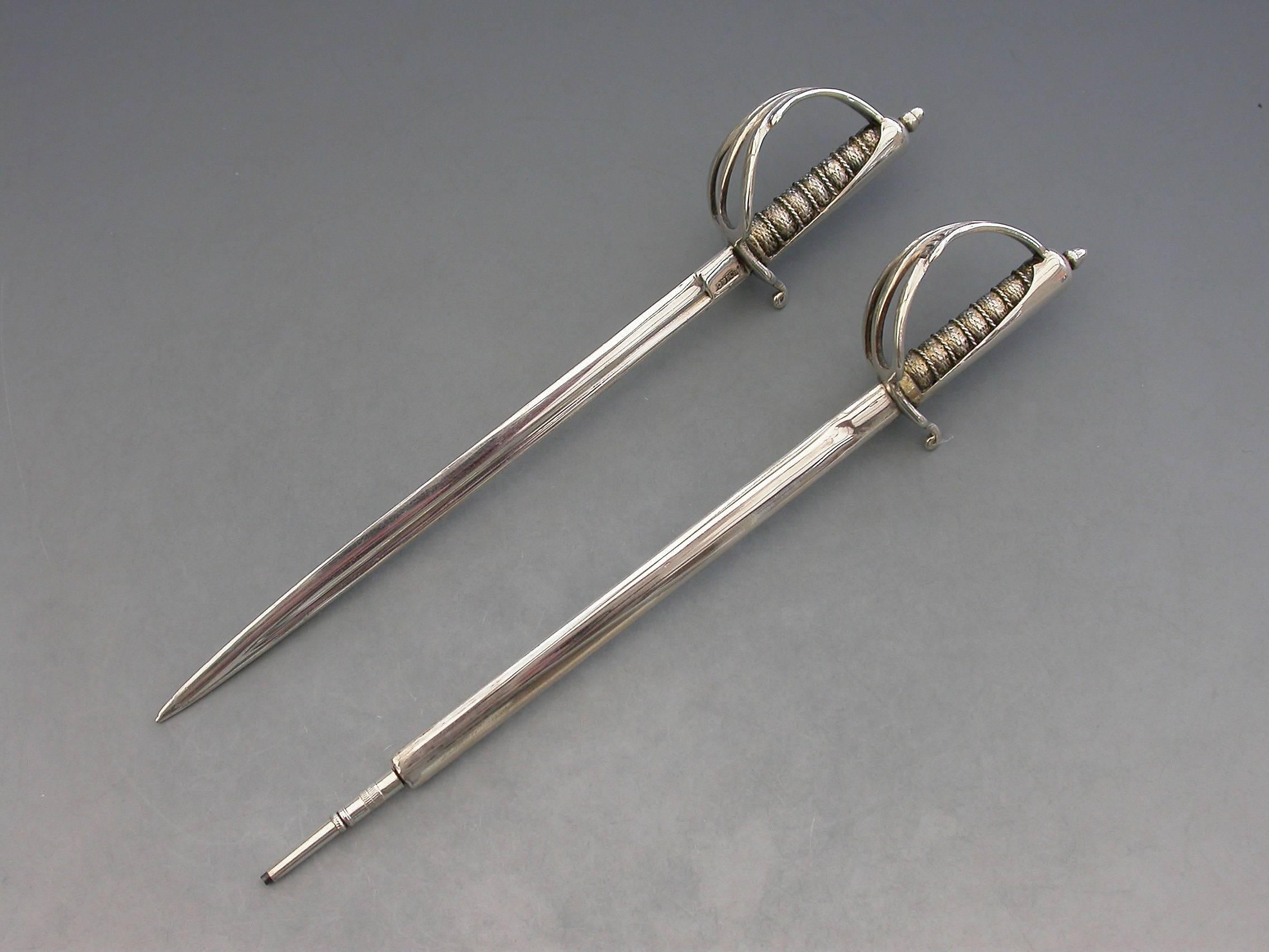A Victorian silver desk clip mounted on a leather covered wooden base, formed as a crossed pair of British officers dress swords complete with suspension rings and scabbards mounted on a sprung hinged stand. One sword is a propelling pencil and the