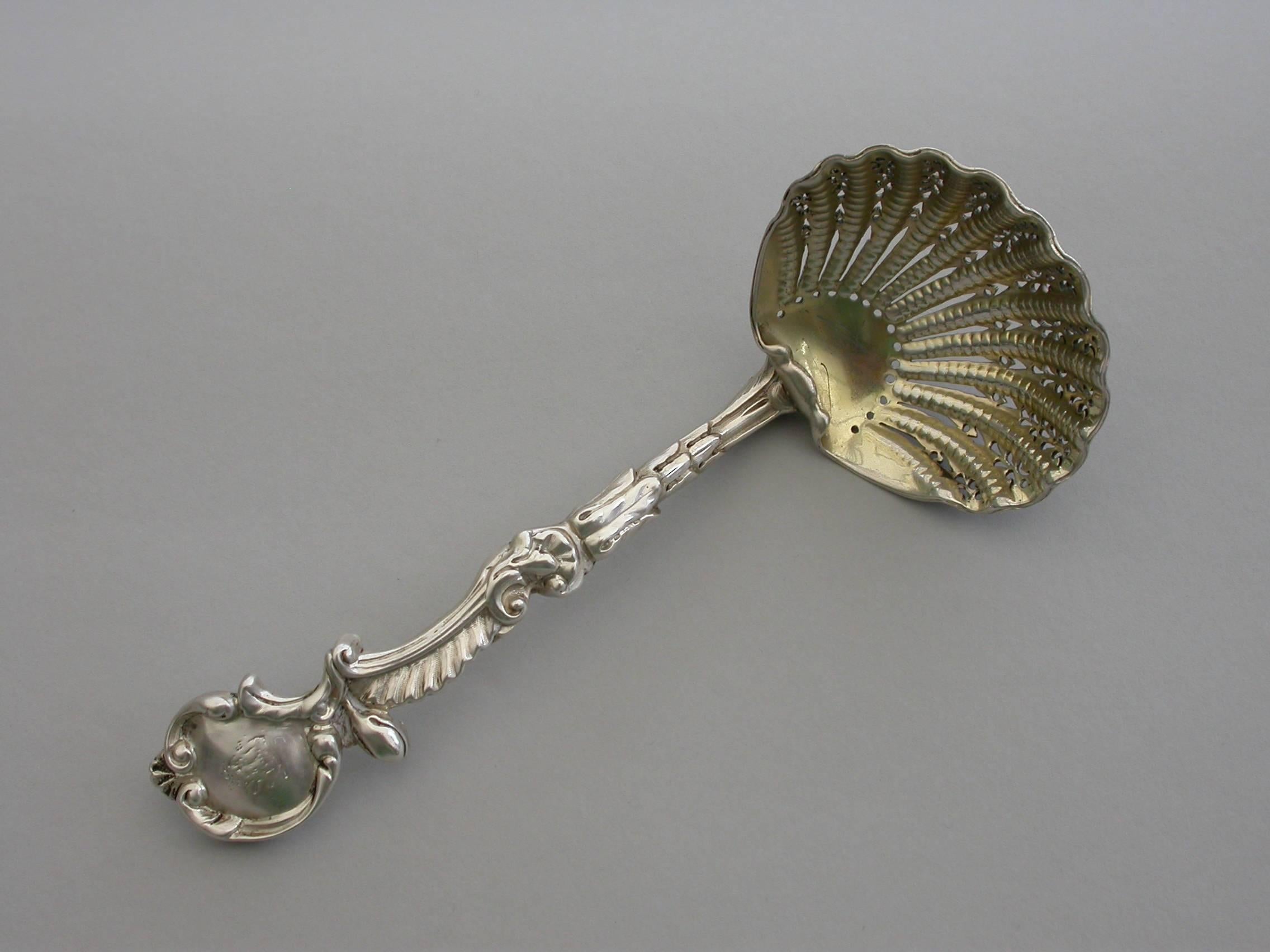A good quality cast silver sugar sifter ladle with Rococo scroll pattern handle, the pierced gilded scallop shaped bowl with turned over rim.

By H J Lias & Son, London, 1871

In good condition with minor scratches to the gilded bowl and the