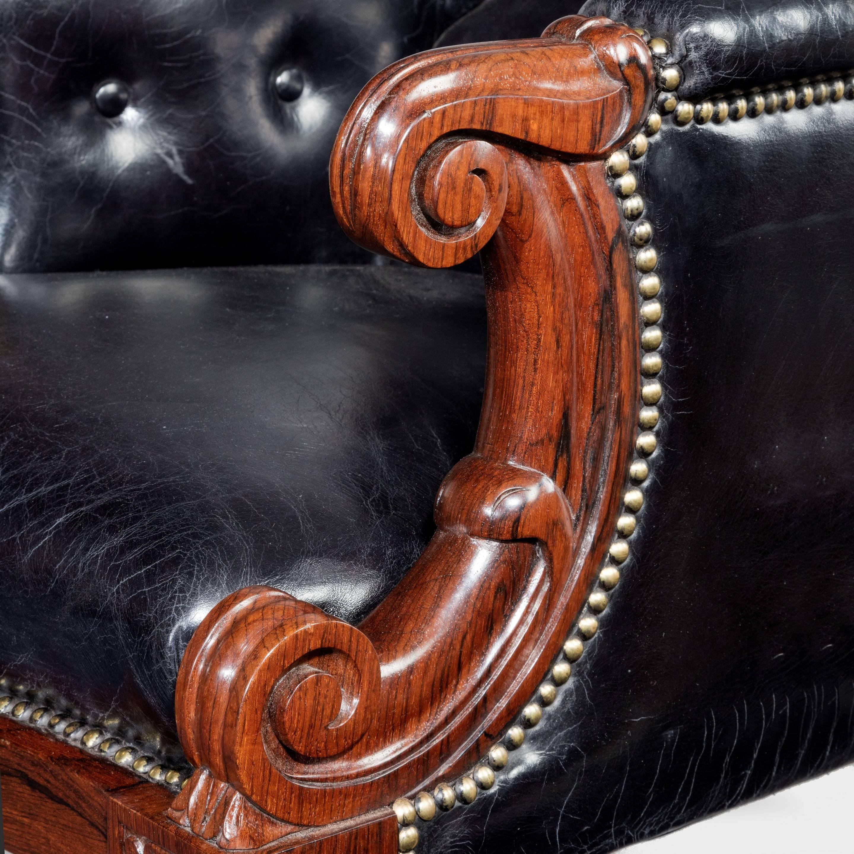 An early Victorian rosewood library chair, with a high back and scroll arms on turned tapering legs, with leather upholstery.
 