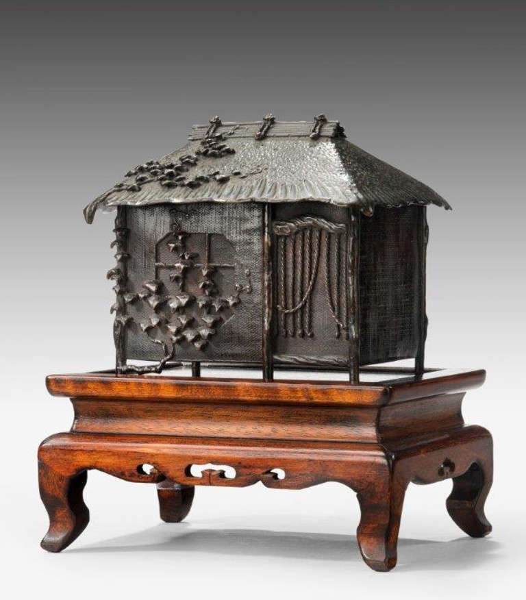 An unusual signed bronze Meiji period censor on hard wood stand, circa 1900.