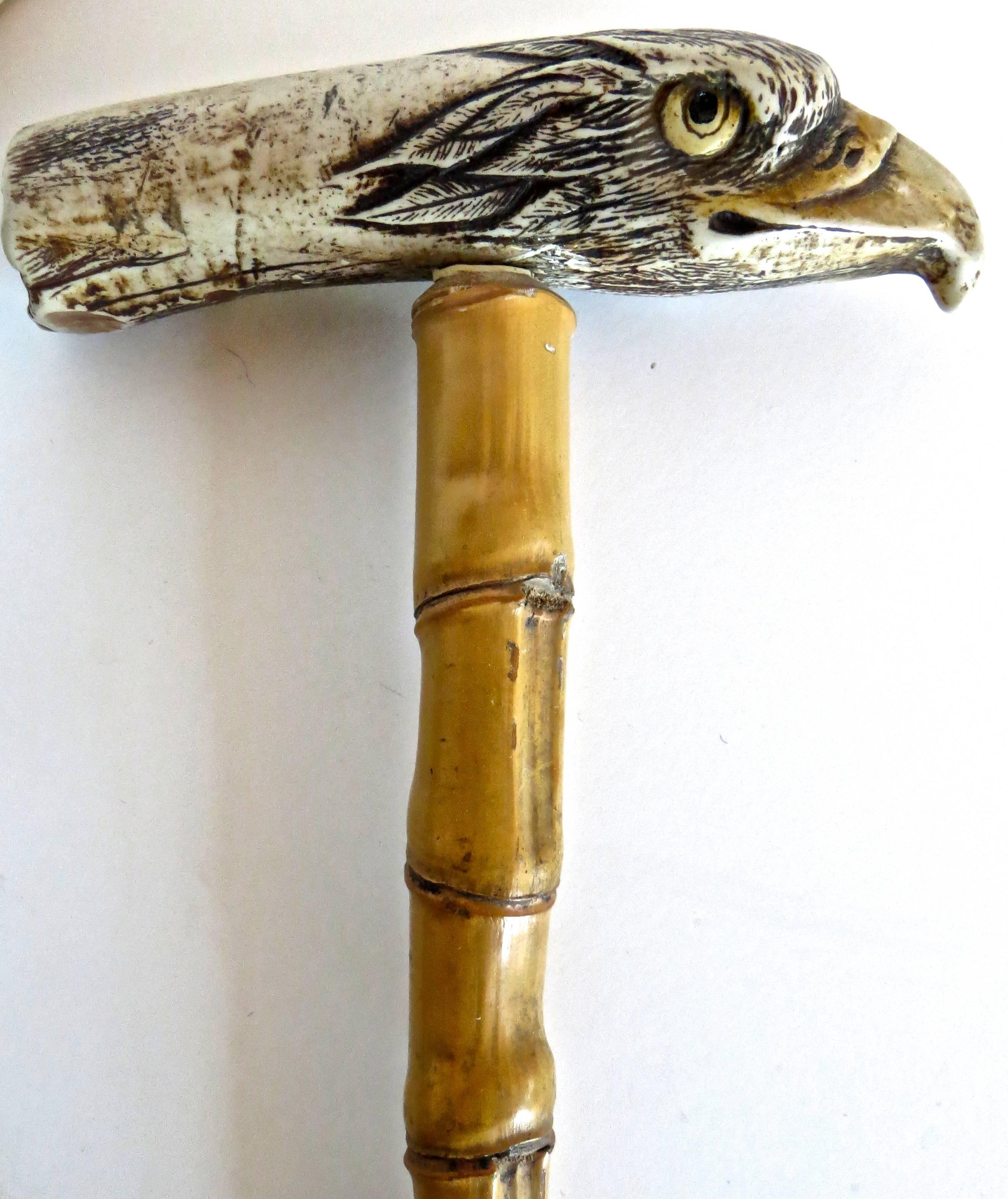 Late 19th century walking stick (cane) with a bone hand-carved handle in the shape and likeness of an eagle; mounted on hickory wood; tapered and ending in a wrapped pewter band. Realistic eagle features on the handle are highlighted and painted